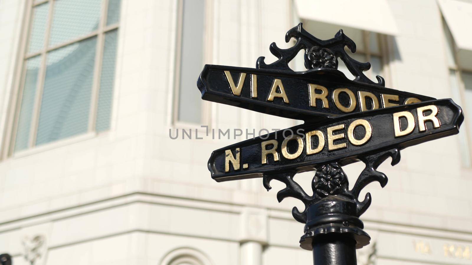 World famous Rodeo Drive symbol, Cross Street Sign, Intersection in Beverly Hills. Touristic Los Angeles, California, USA. Rich wealthy life consumerism, Luxury brands and high-class stores concept. by DogoraSun