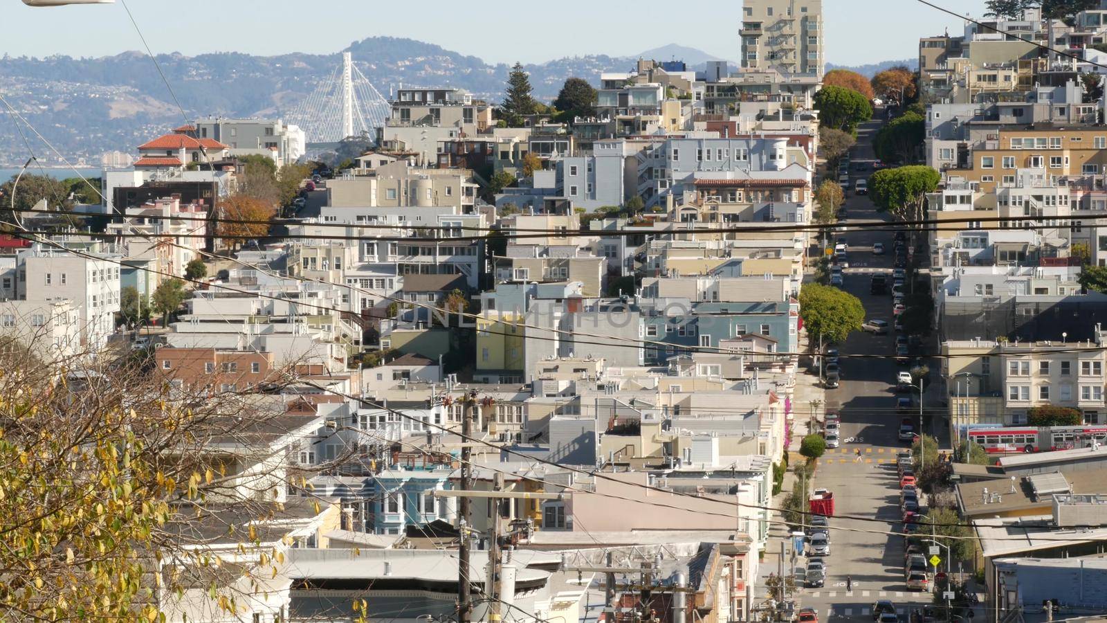 Iconic hilly street and crossroads in San Francisco, Northern California, USA. Steep downhill road and pedestrian walkway. Downtown real estate, victorian townhouses abd other residential buildings by DogoraSun