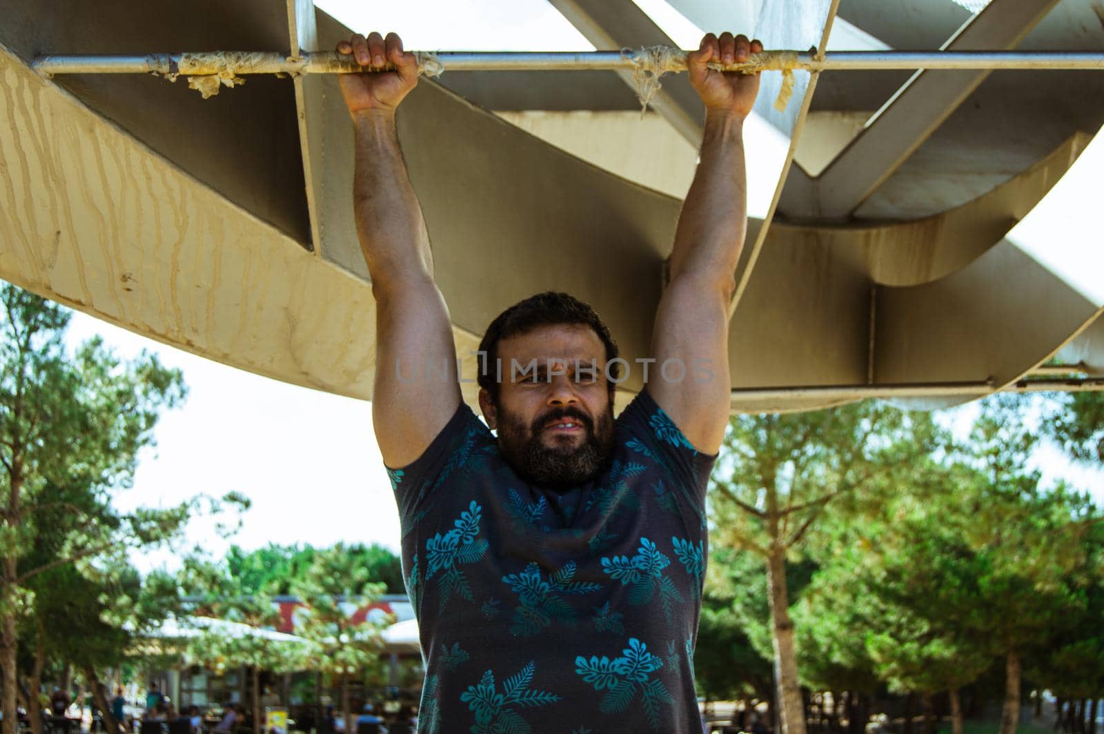 Man playing sports in a park in the afternoon and wearing a flower T-shirt