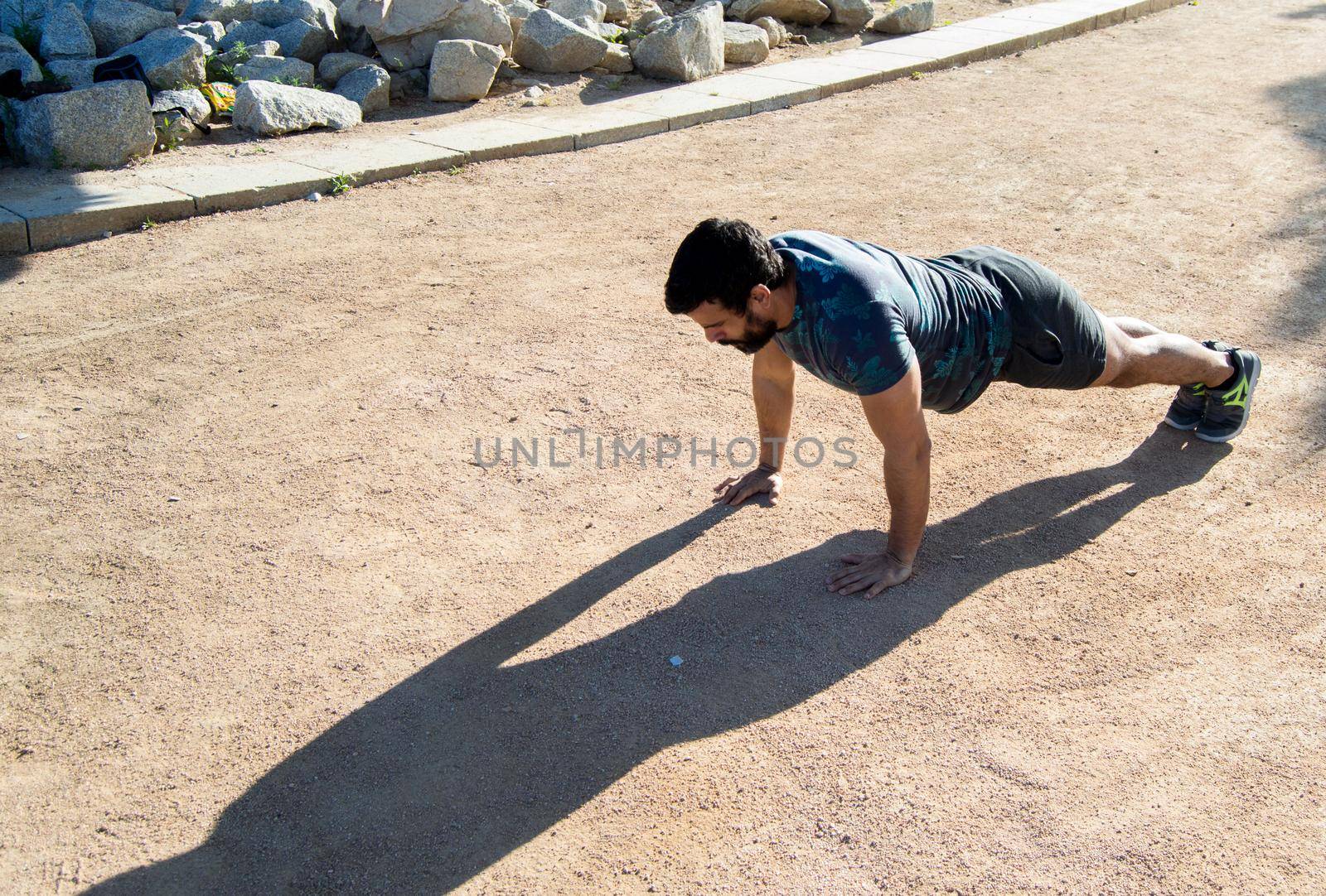 Strong build man in short sleeve t-shirt doing exercise by xavier_photo