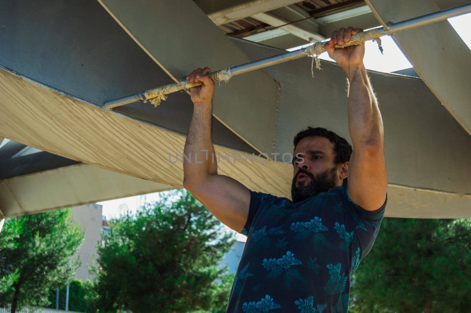 Strong build man in short sleeve t-shirt doing exercise by xavier_photo