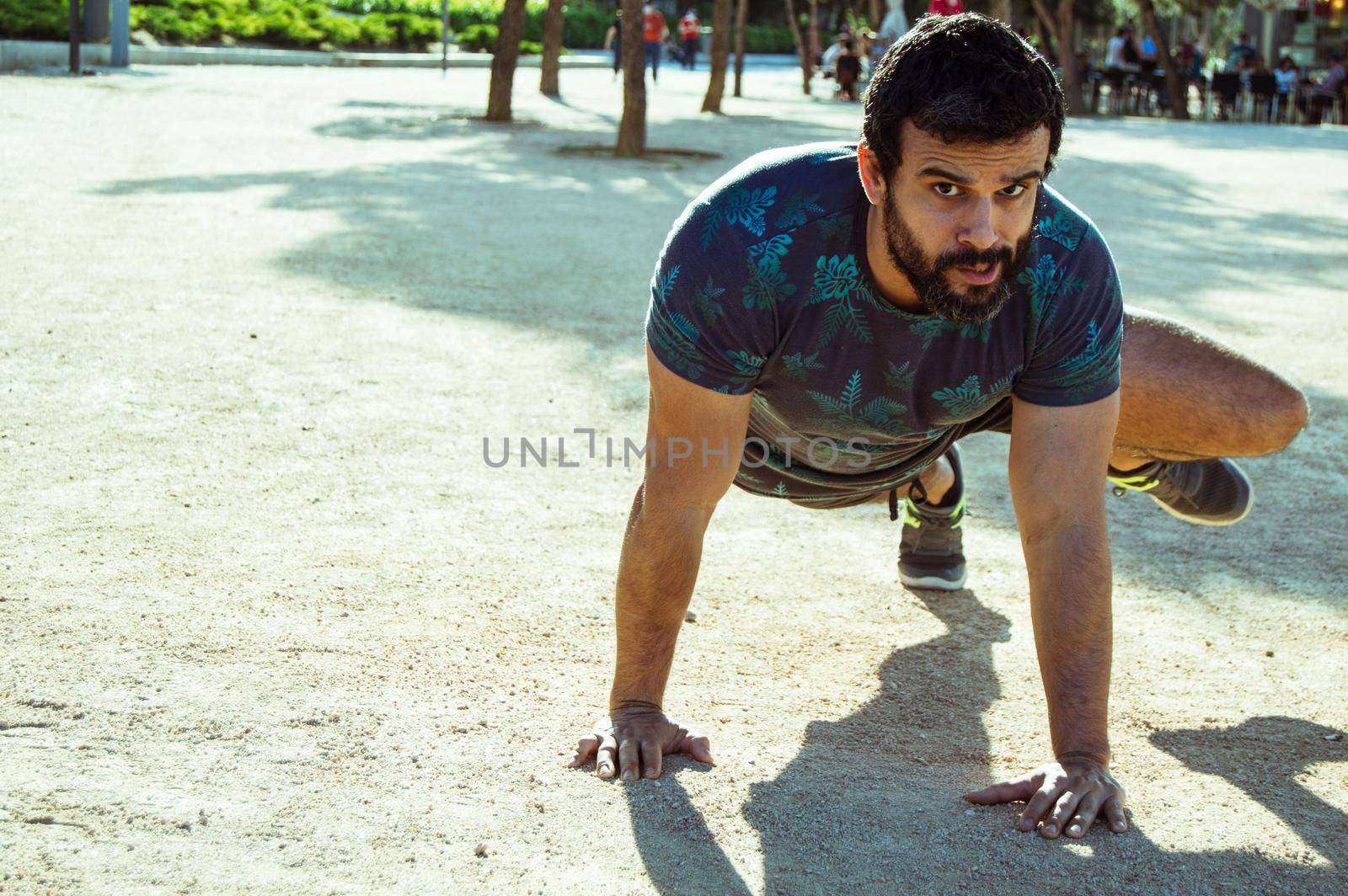 Man playing sports in a park in the afternoon and wearing a flower T-shirt