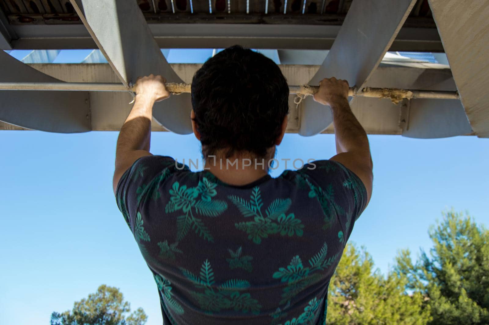 Strong build man in short sleeve t-shirt doing exercise by xavier_photo