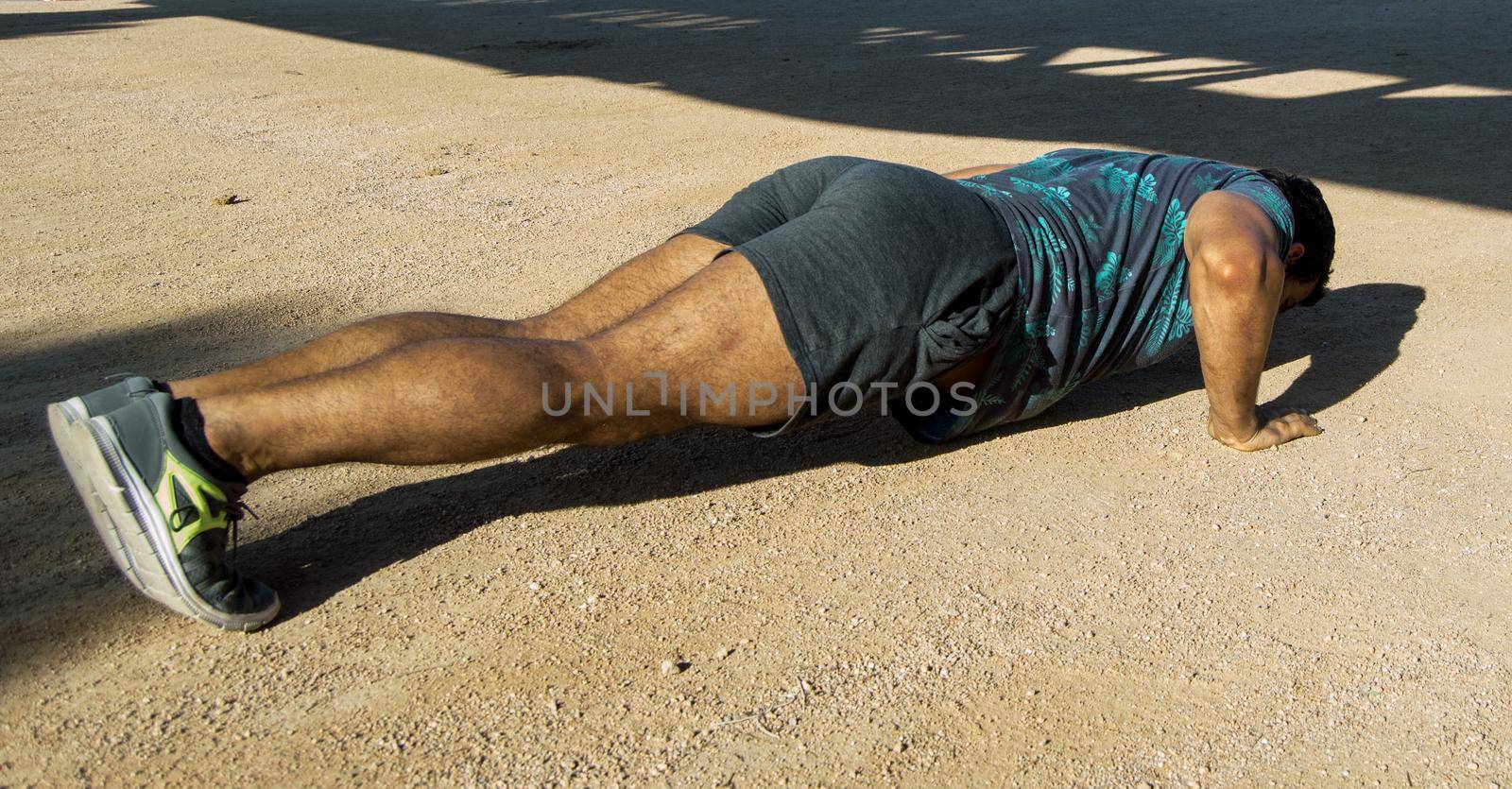 Strong build man in short sleeve t-shirt doing exercise by xavier_photo