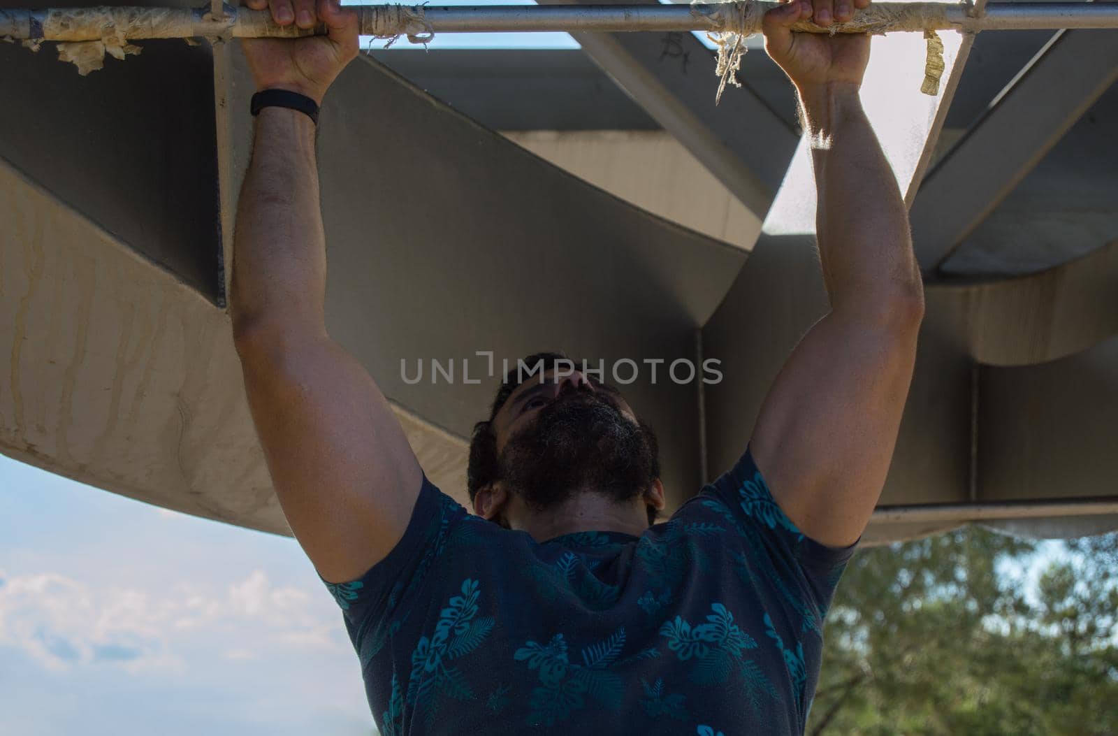 Strong build man in short sleeve t-shirt doing exercise by xavier_photo