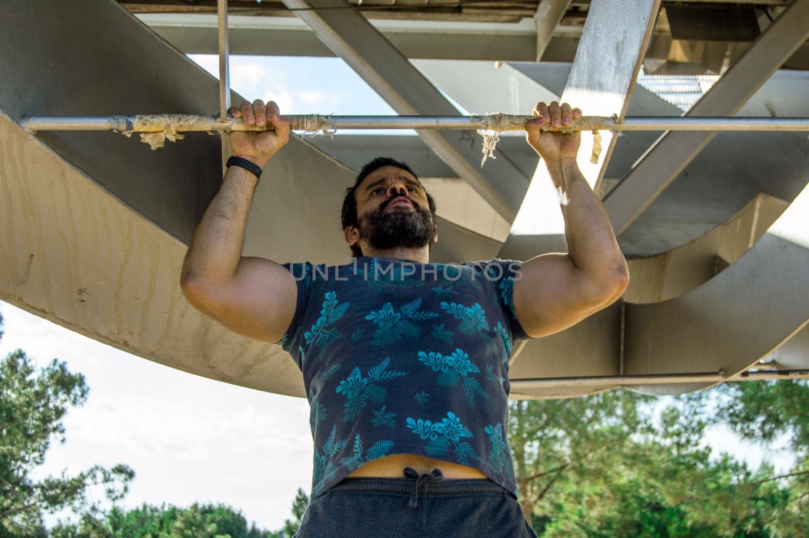 Strong build man in short sleeve t-shirt doing exercise by xavier_photo