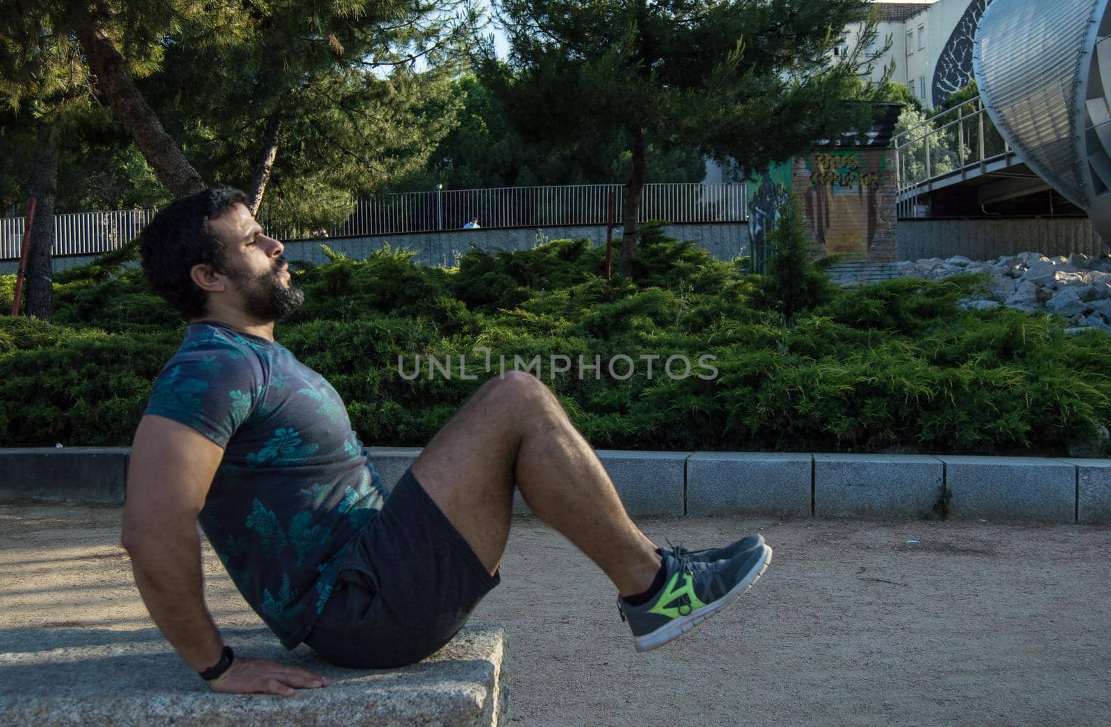 Strong build man in short sleeve t-shirt doing exercise by xavier_photo