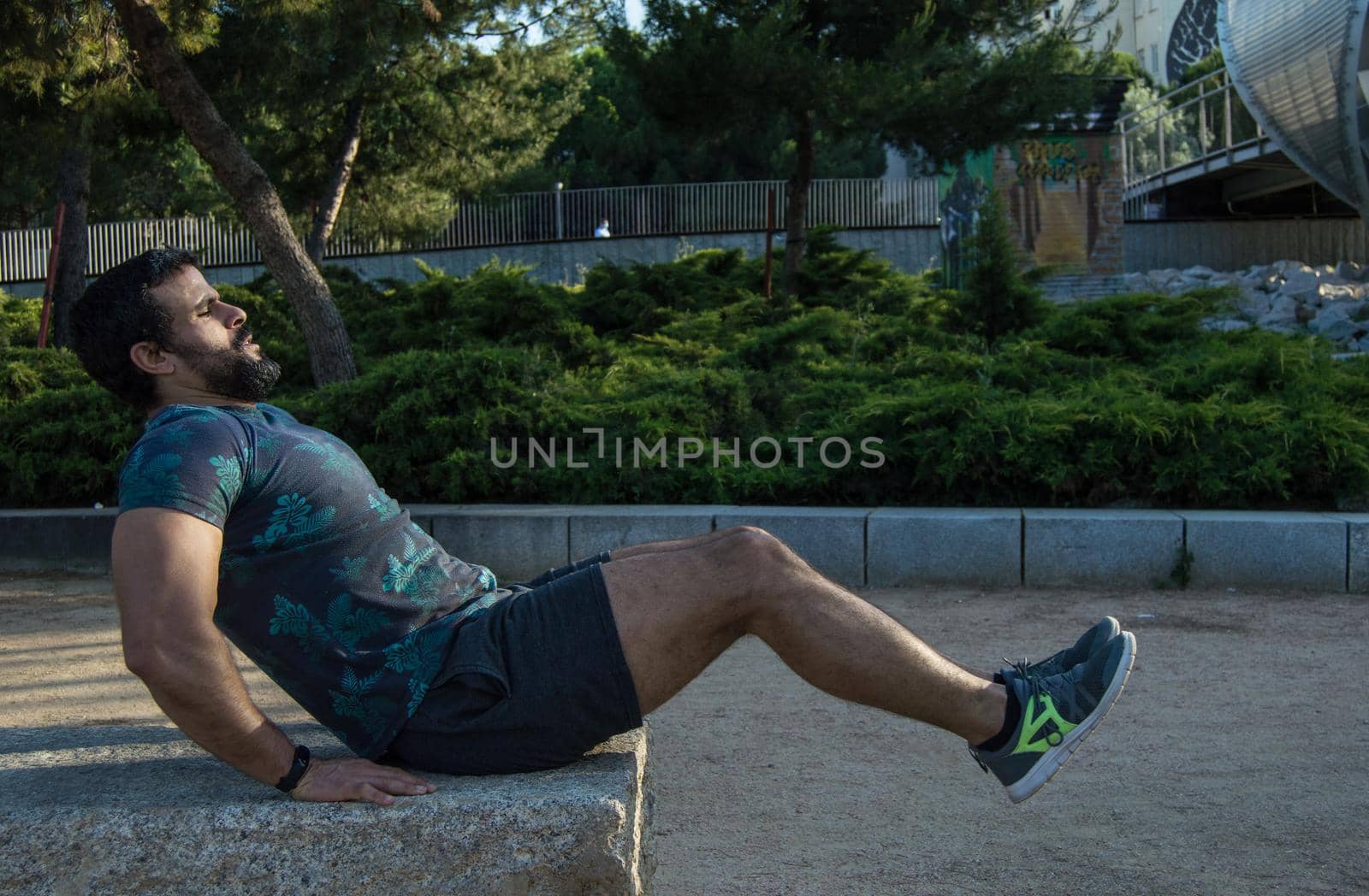 Man playing sports in a park in the afternoon and wearing a flower T-shirt
