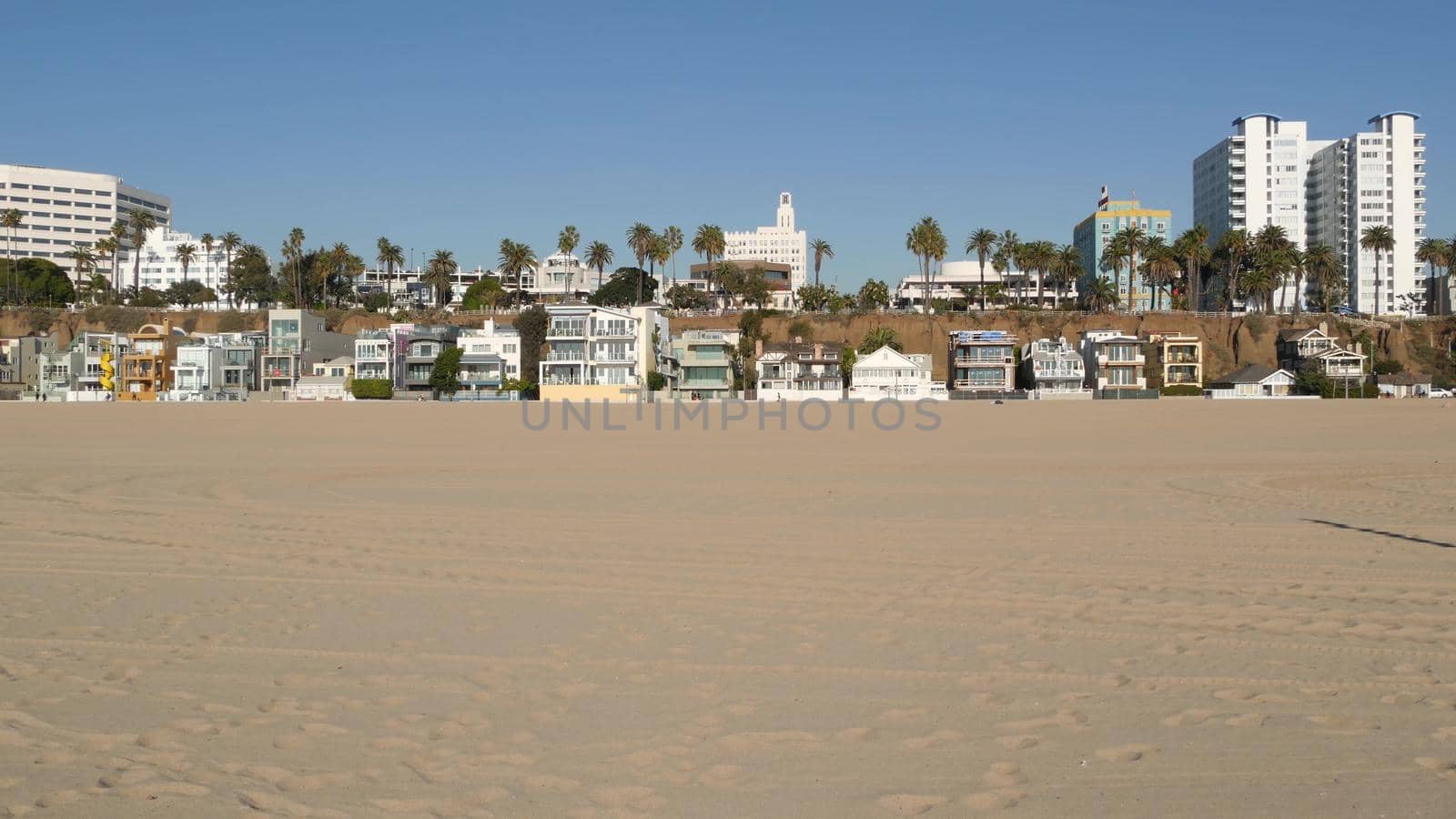 California summertime beach aesthetic, sunny blue sky, sand and many different beachfront weekend houses. Seafront buildings, real estate in Santa Monica pacific ocean resort near Los Angeles CA USA.