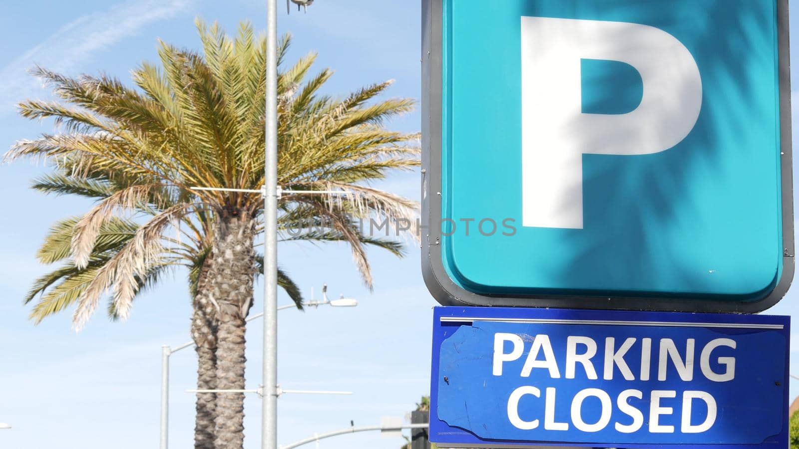 Parking lot sign as symbol of traffic difficulties and transportation issues in busy urban areas of USA. Public paid parking zone in downtown of San Diego, California. Limited space for cars in city.