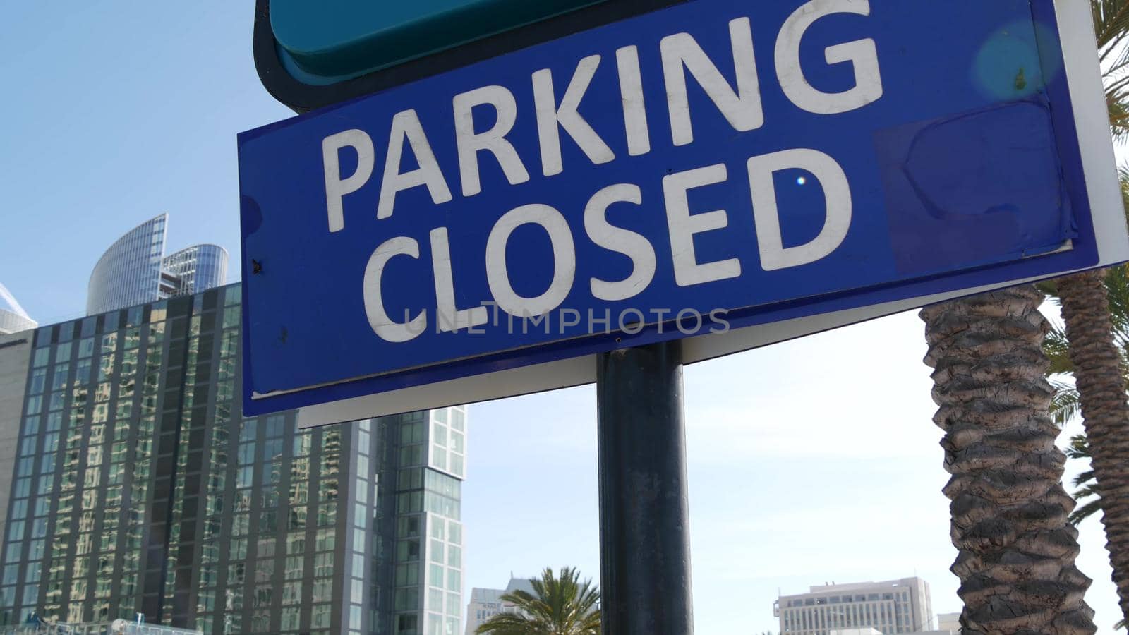 Parking lot sign as symbol of traffic difficulties and transportation issues in busy urban areas of USA. Public paid parking zone in downtown of San Diego, California. Limited space for cars in city.