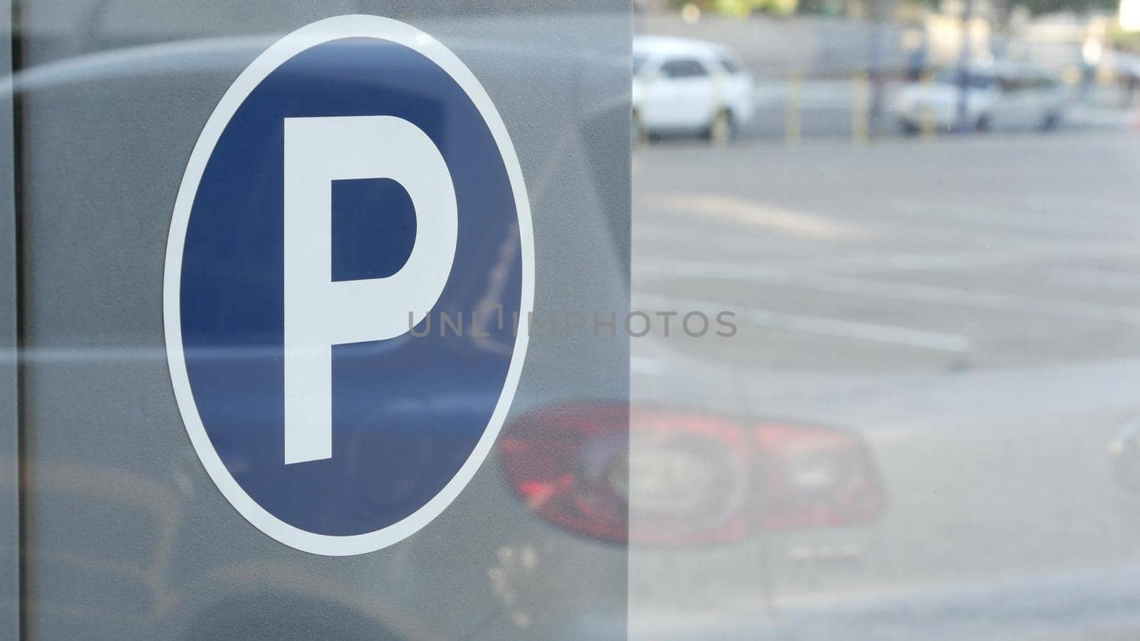 Parking lot sign as symbol of traffic difficulties and transportation issues in busy urban areas of USA. Public paid parking zone in downtown of San Diego, California. Limited space for cars in city.