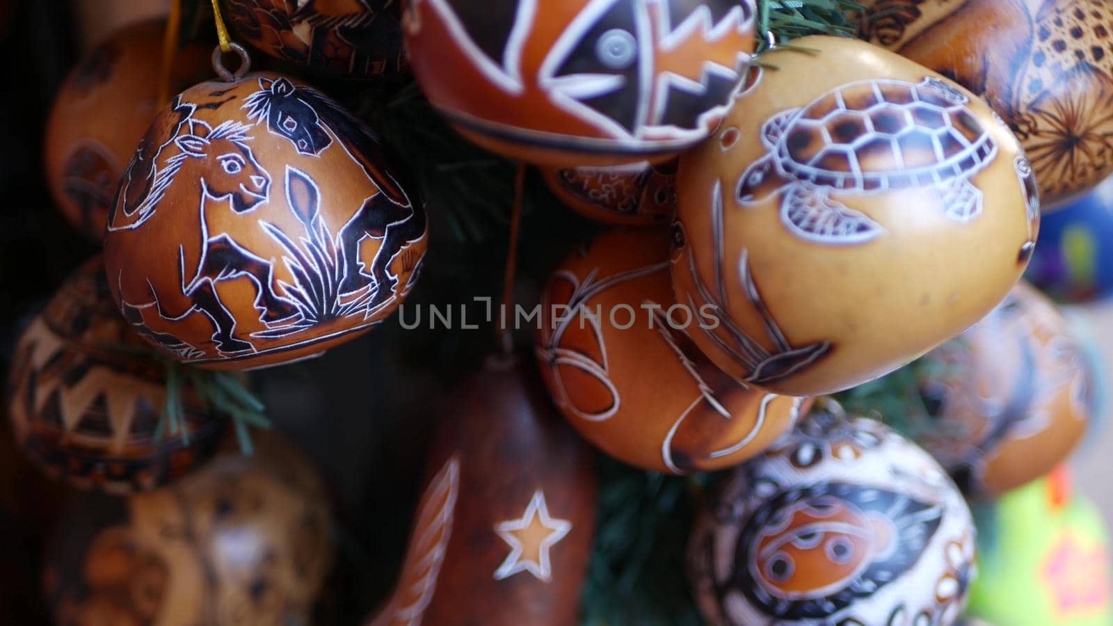 Wooden ornamental handmade mexican decor. Indigenous souvenirs hanging on new year tree, handicraft market, California USA. Hispanic authentic pattern, folk traditional handiwork from Latin America.