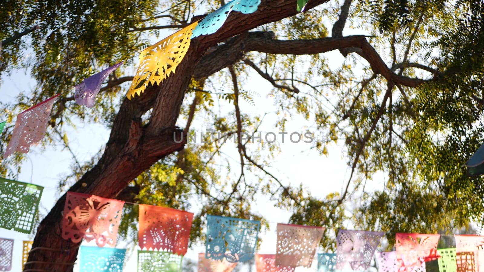 Colorful mexican perforated papel picado banner, festival colourful paper garland. Multi colored hispanic folk carved tissue flags, holiday or carnival. Authentic fiesta decoration in Latin America by DogoraSun