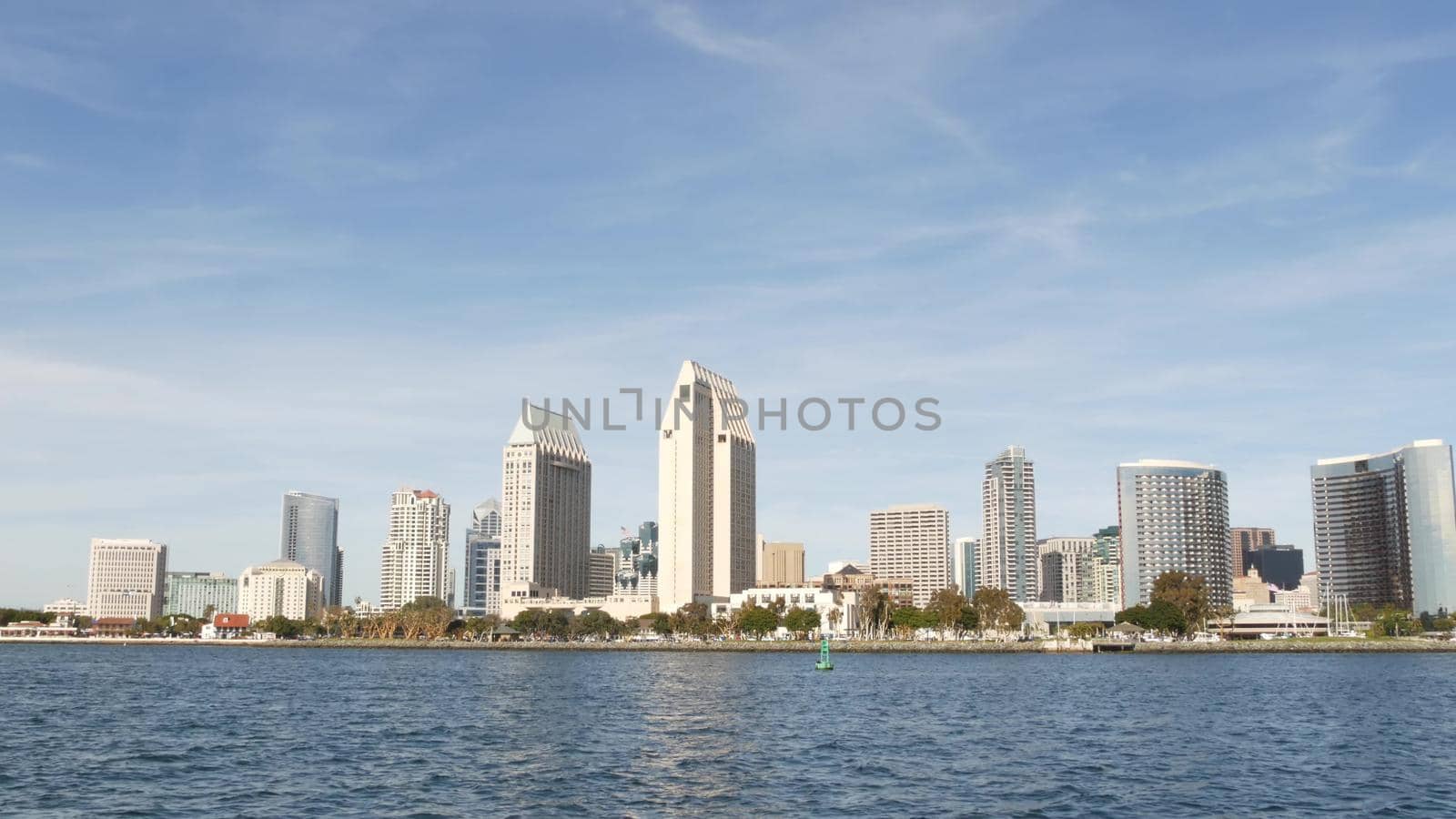 Metropolis urban skyline, highrise skyscrapers of city downtown, San Diego Bay, California USA. Waterfront buildings near pacific ocean harbour. View from boat, nautical public transport to Coronado.