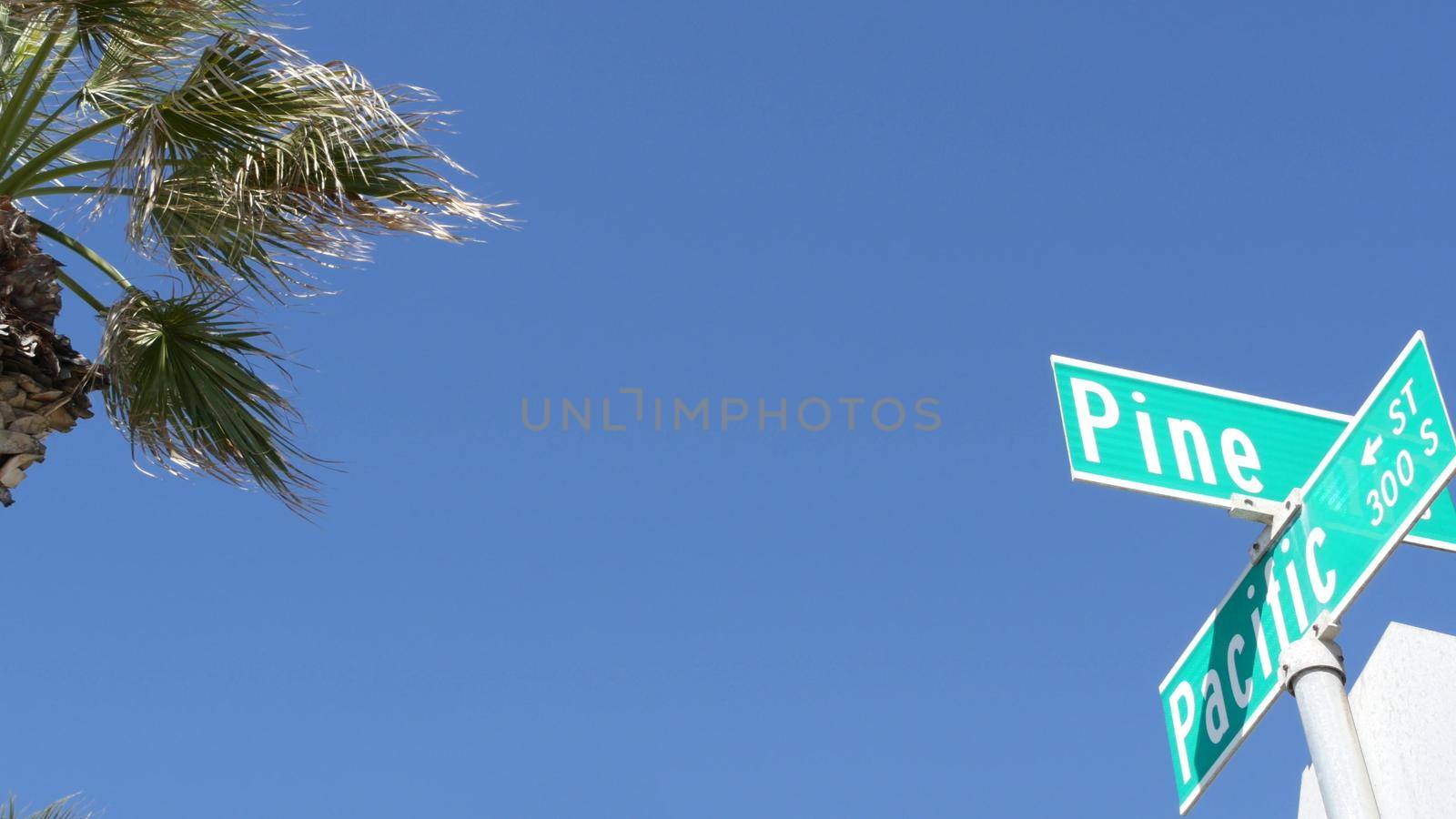 Pacific street road sign on crossroad, route 101 tourist destination, California, USA. Lettering on intersection signpost, symbol of summertime travel and vacations.Signboard in city near Los Angeles by DogoraSun