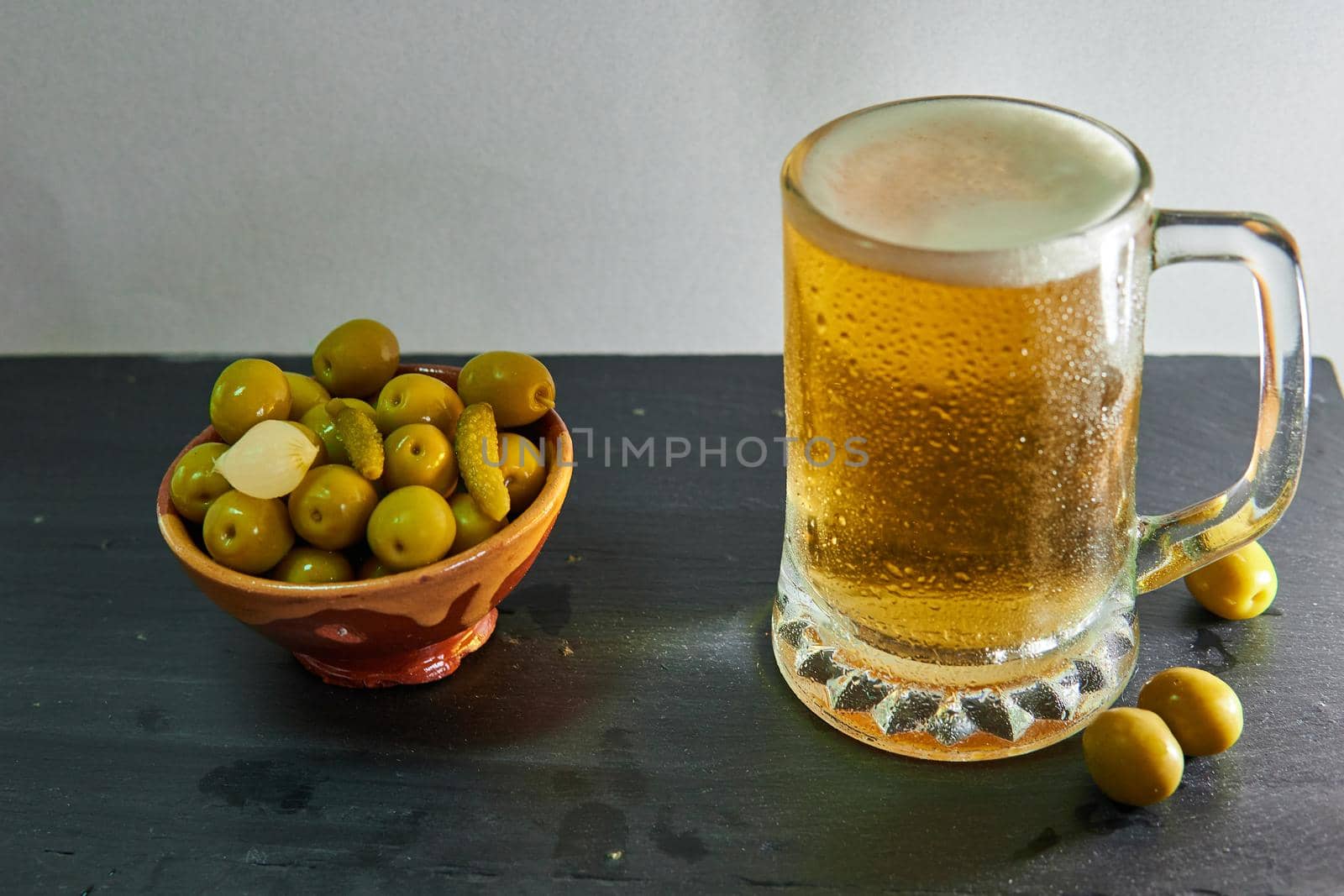Black-based beer mug with olives