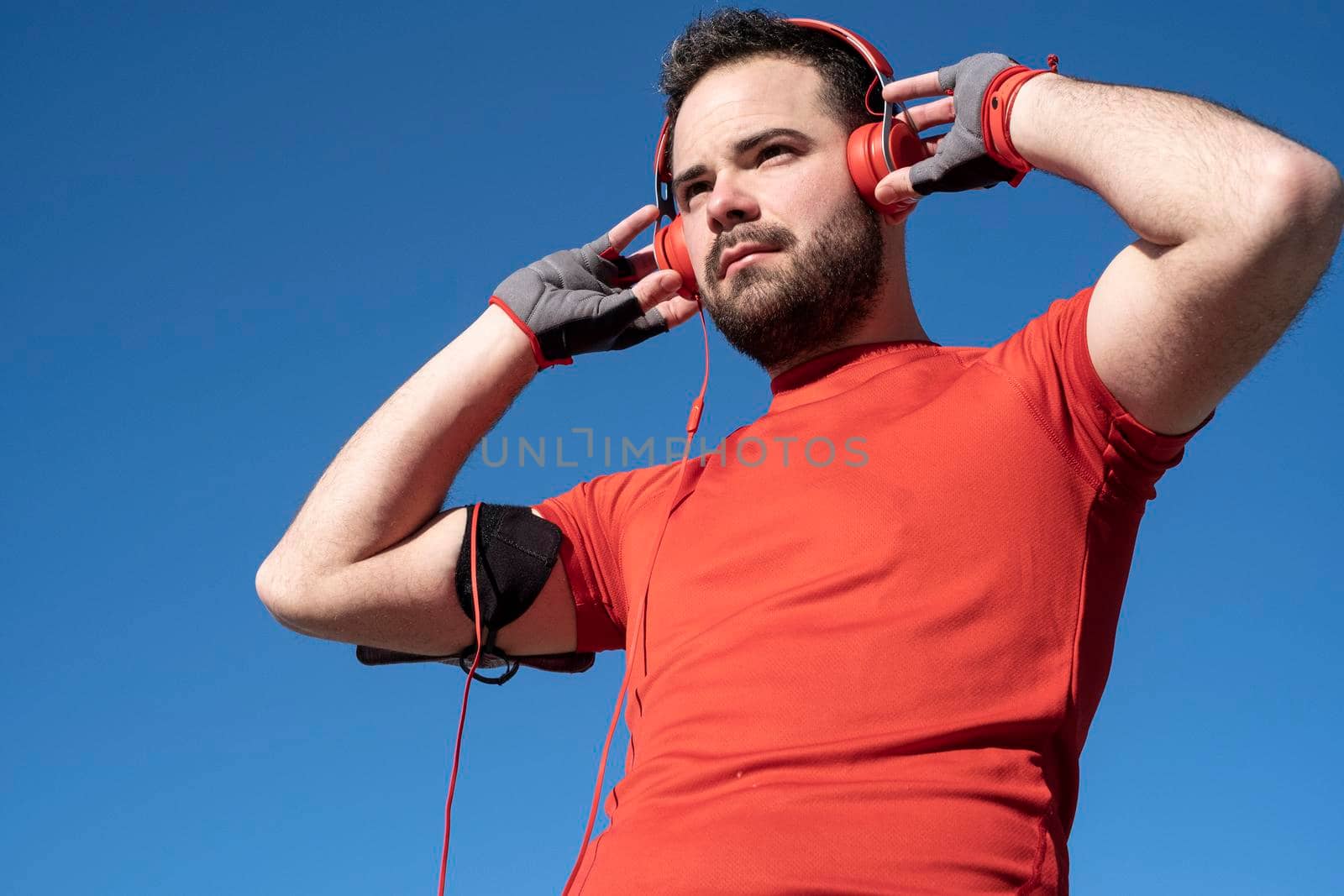 young man preparing to run with a pair of headphones