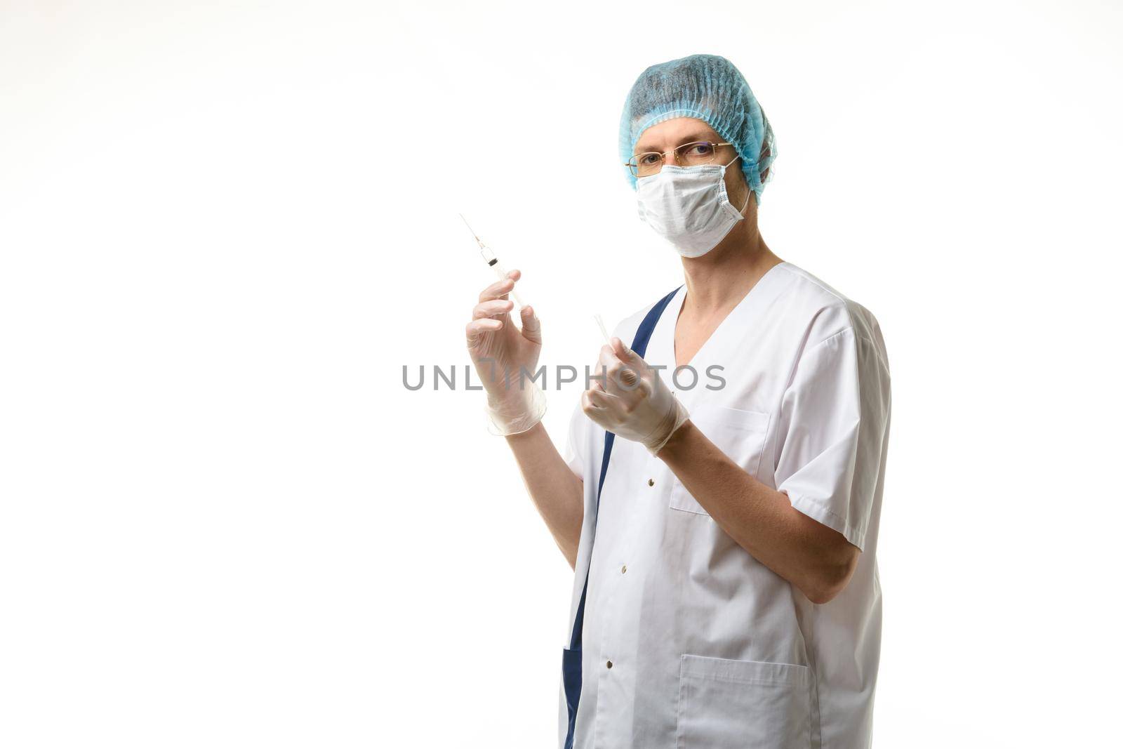 Surgeon holds a syringe in his hands and looked into the frame, isolated on white background