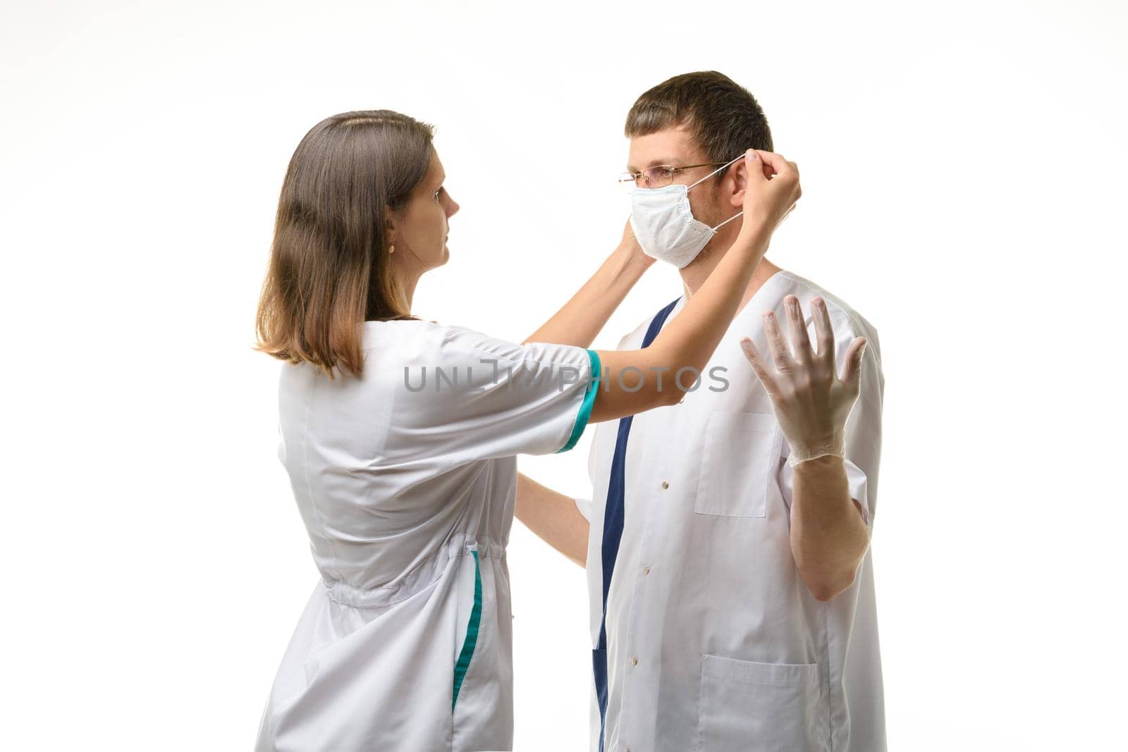 The nurse puts a medical mask on the doctor's face