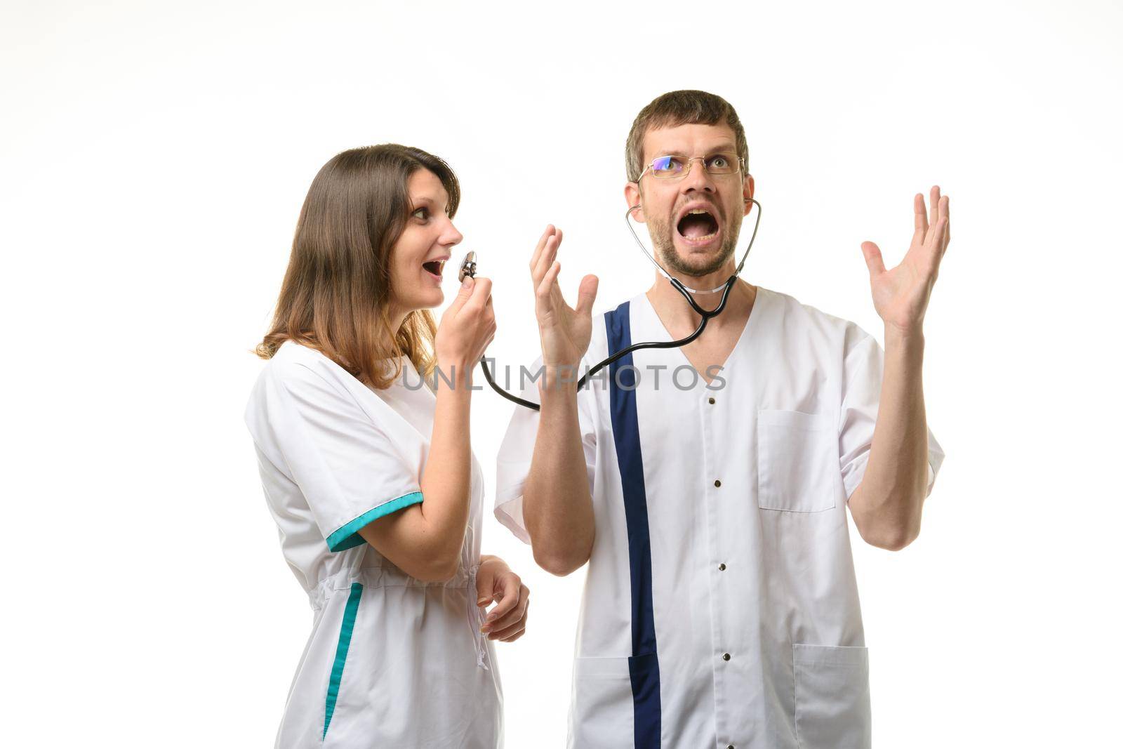 Girl doctor screams into the head of the phonendoscope worn by the doctor, the doctor screams from a loud sound