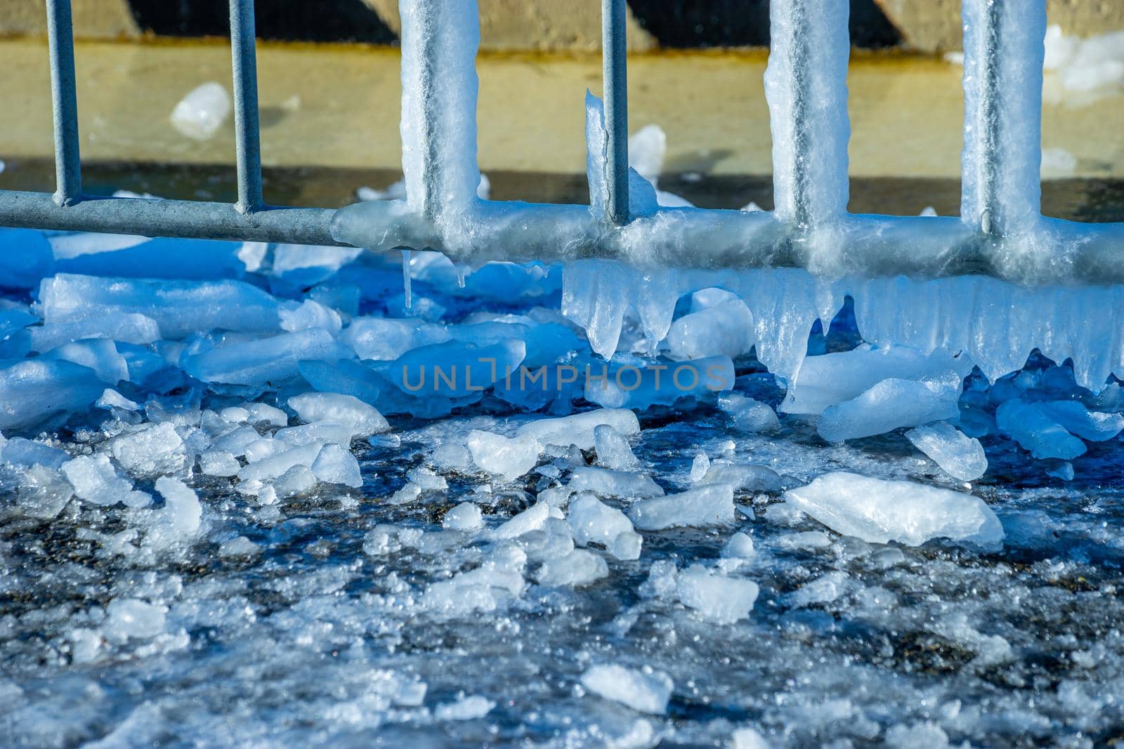 Metal construction in ice on a blurred background.