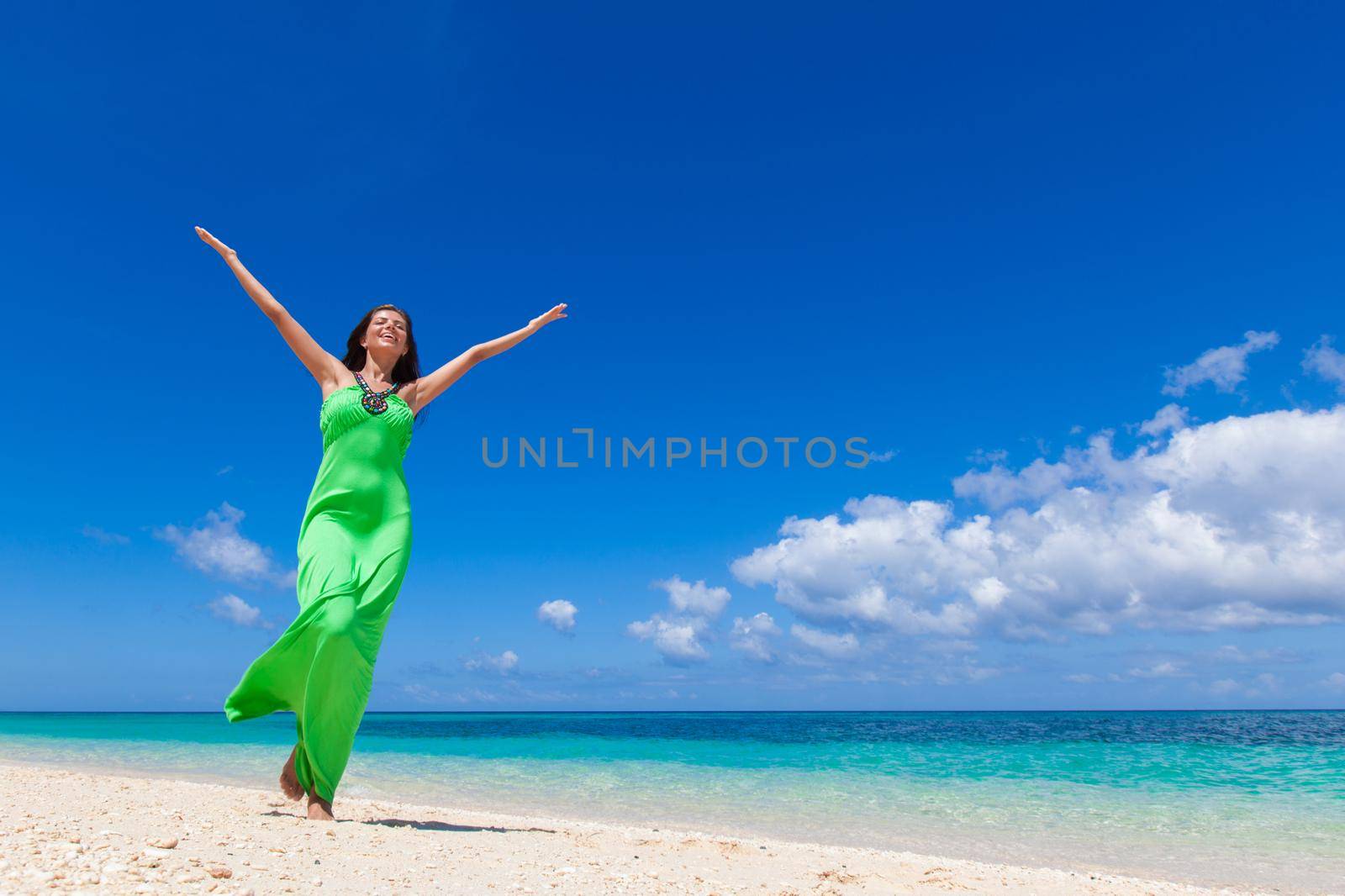 Woman in green dress on beach by Yellowj