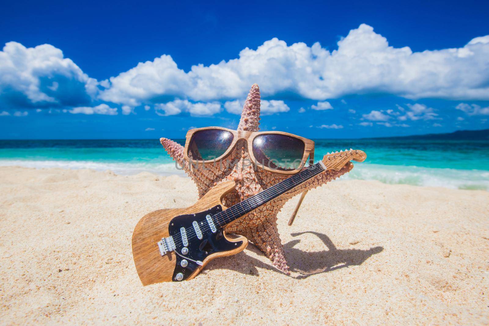 Starfish guitar player on sand of tropical beach at Philippines