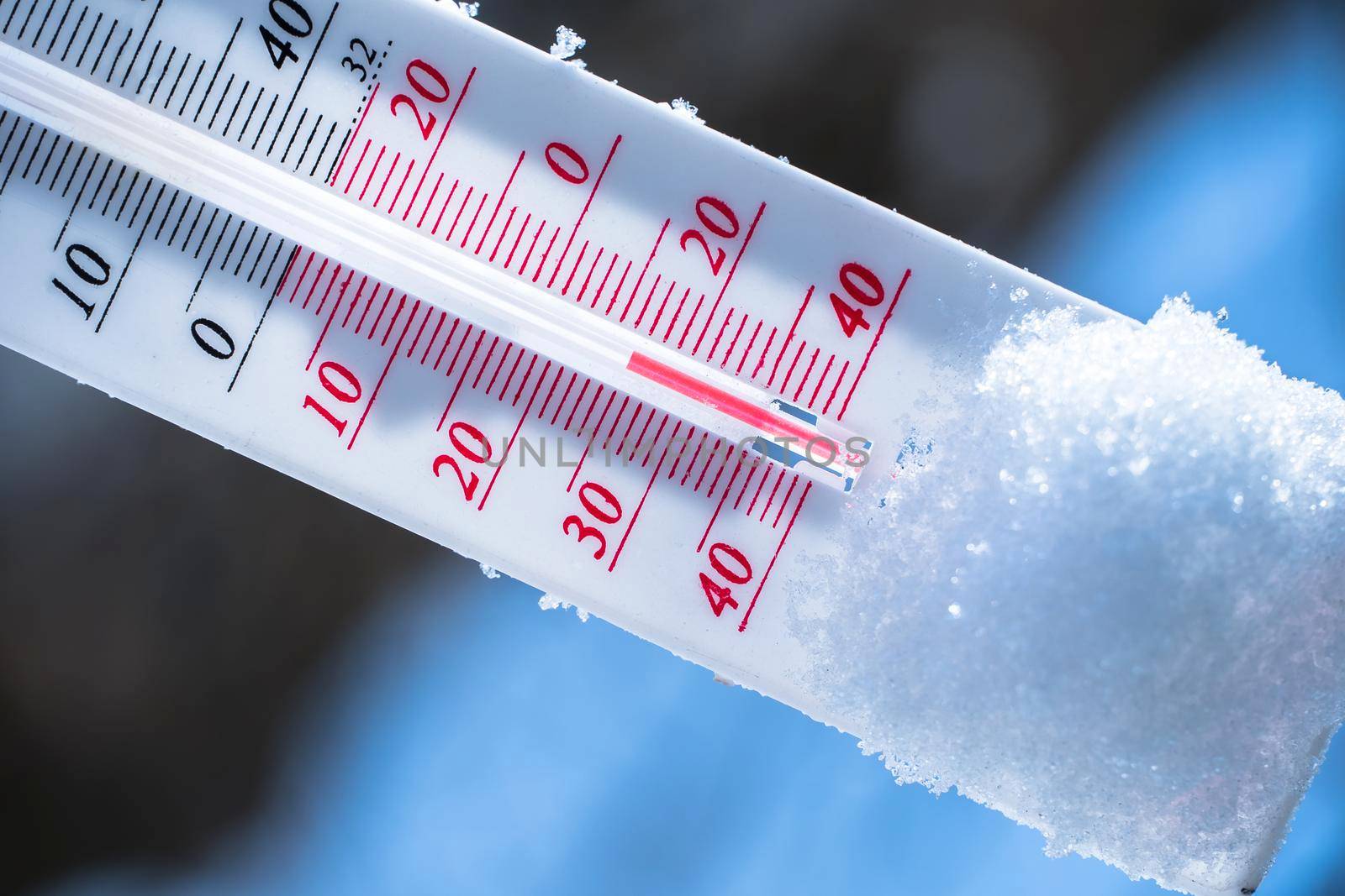 The thermometer lies on the snow in winter showing a negative temperature. Meteorological conditions in a harsh climate in winter with low air and ambient temperatures.Freeze in wintertime by YevgeniySam