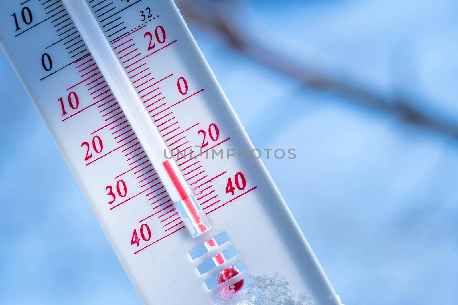 The thermometer lies on the snow in winter showing a negative temperature. Meteorological conditions in a harsh climate in winter with low air and ambient temperatures.Freeze in wintertime