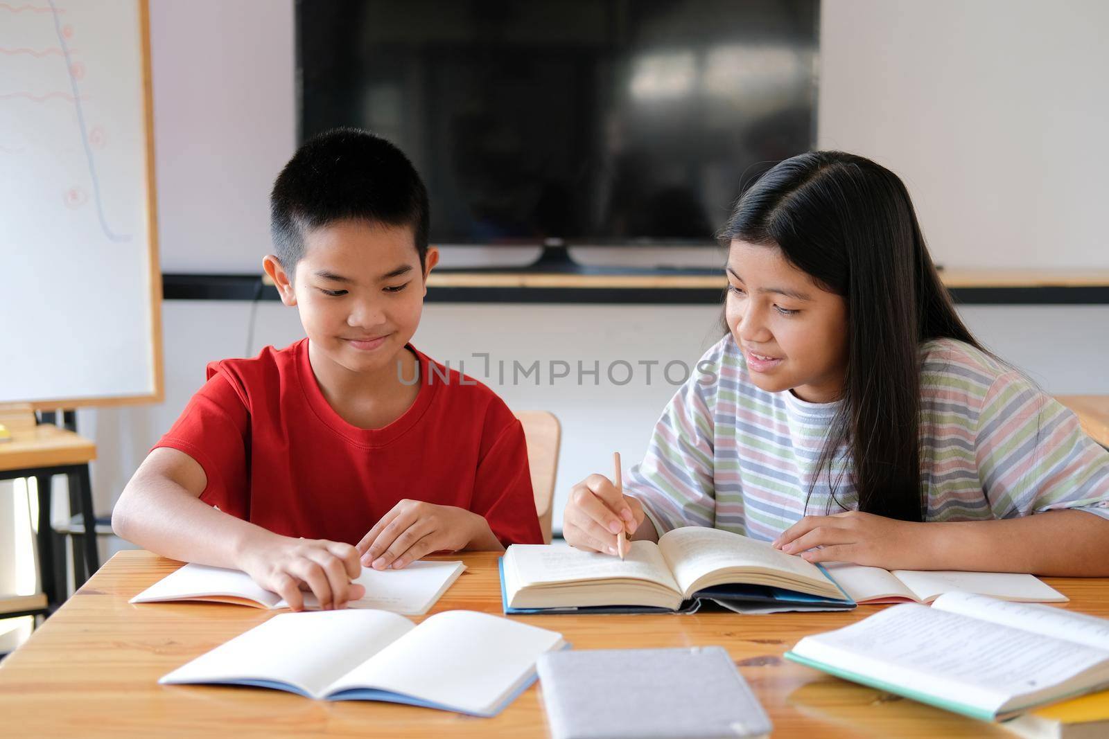 asian boy girl student studying doing homework in library. learning education at school