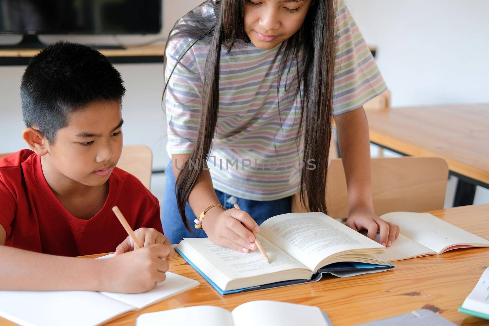 asian boy girl student studying writing notes doing homework in library. learning education at school