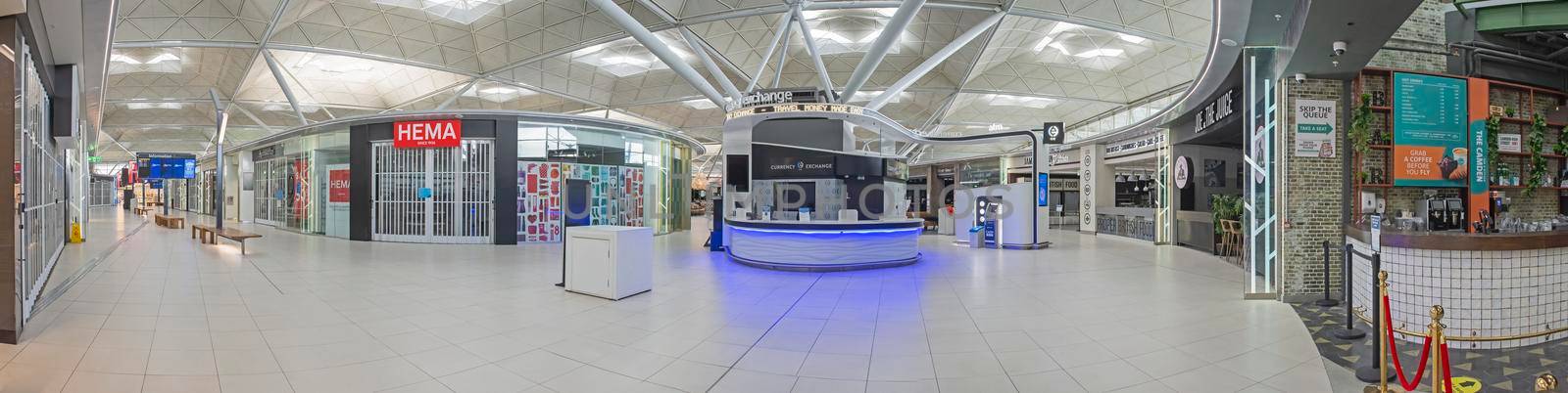 LONDON STANSTED, ENGLAND - FEBRUARY 6TH 2021:  Empty airport departure hall with closed shops on February 6th 2021. International flights were badly affected by the corona virus pandemic travel ban