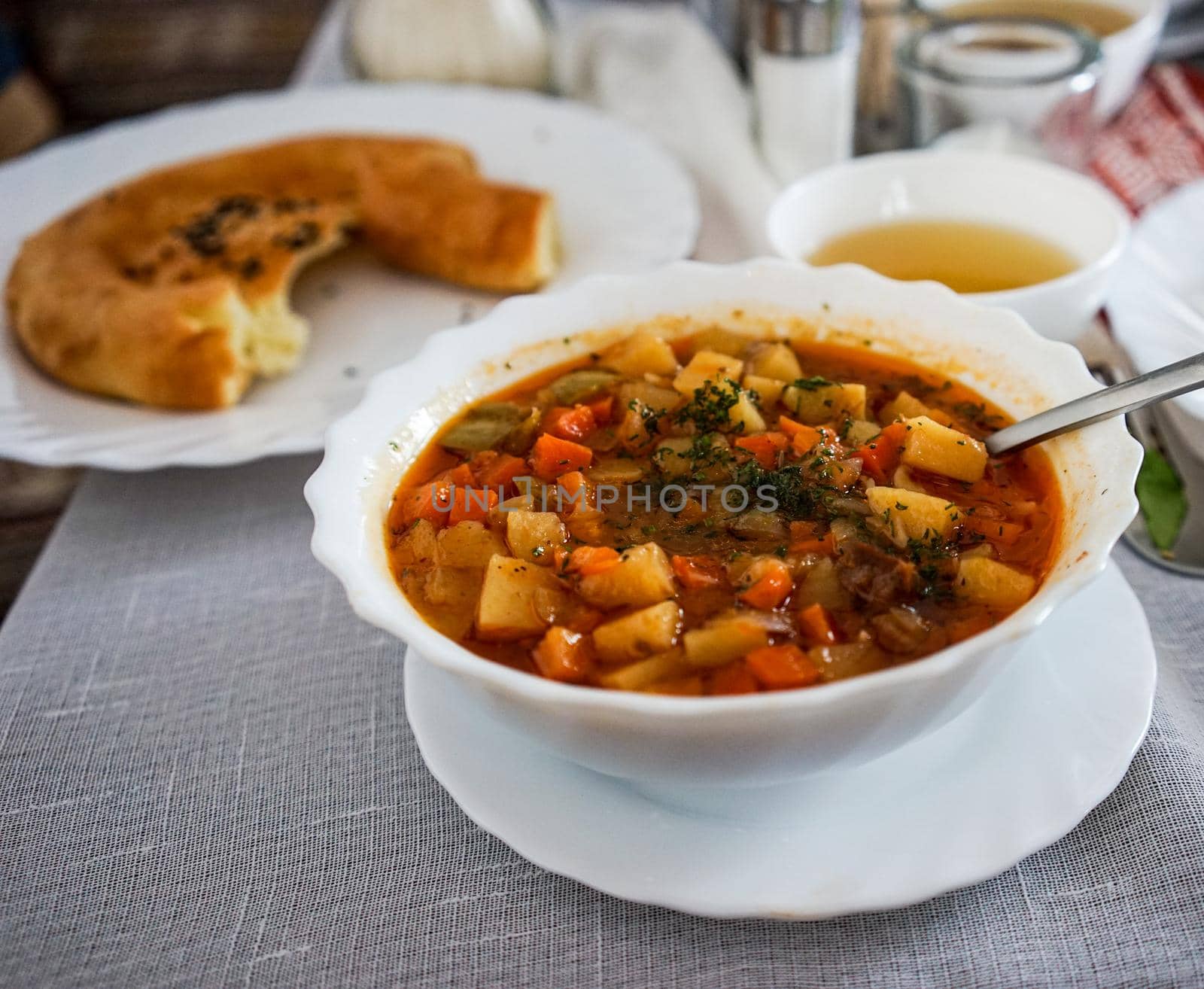 Lagman in a white plate against a white tablecloth, Tatar cuisine