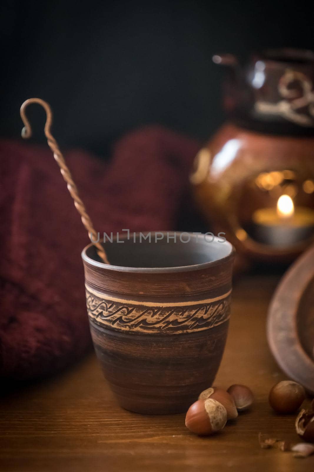 Dark background with a hot drink in a ceramic Cup and the scattered nuts hazelnuts on a wooden surface.