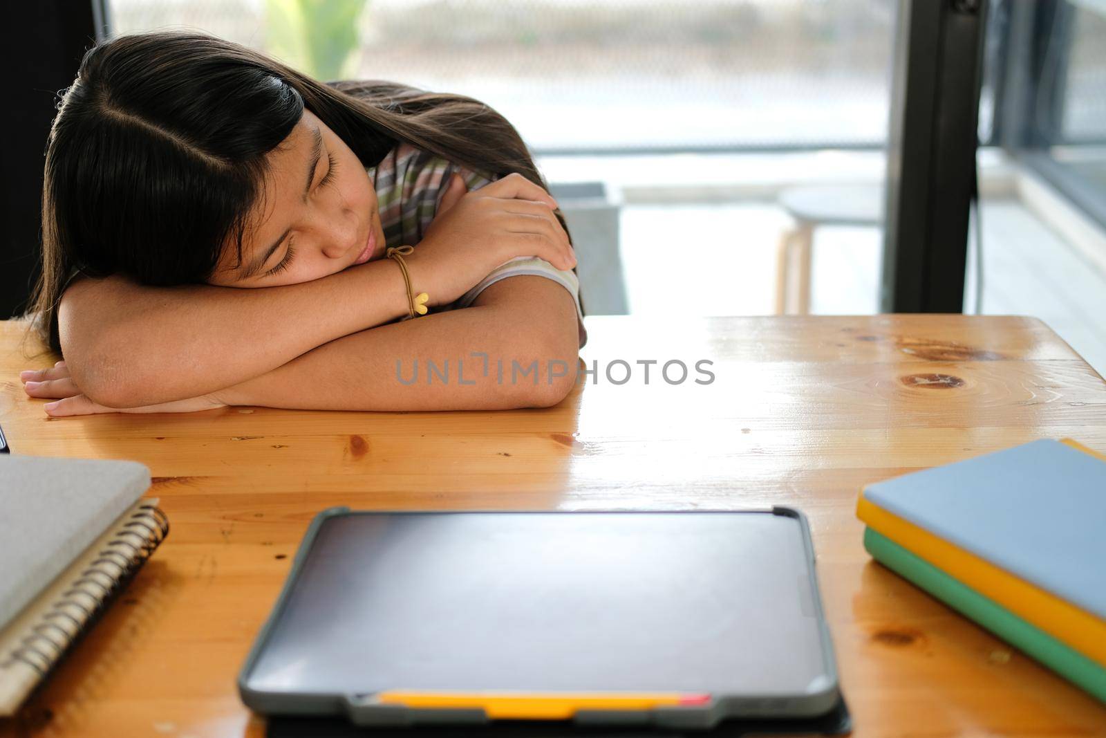 tired exhausted asian girl student sleeping after studying hard exam in library