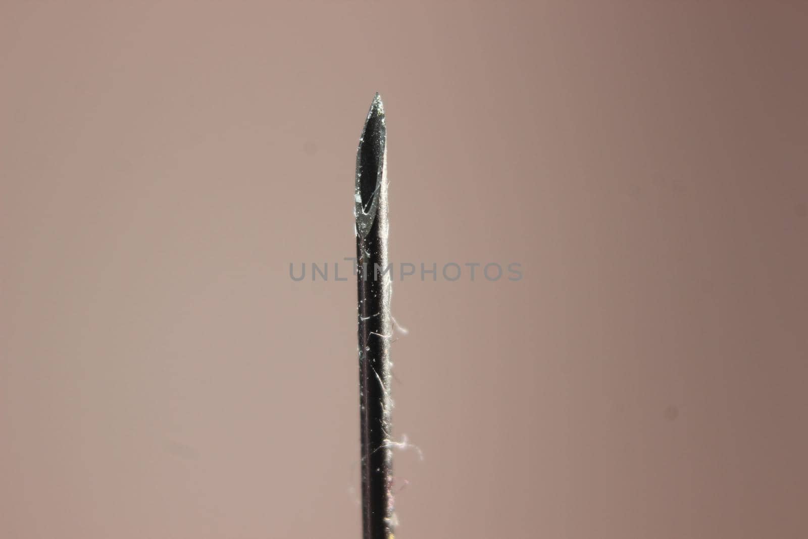 Water drop falling from the syringe needle against grey background by Photochowk