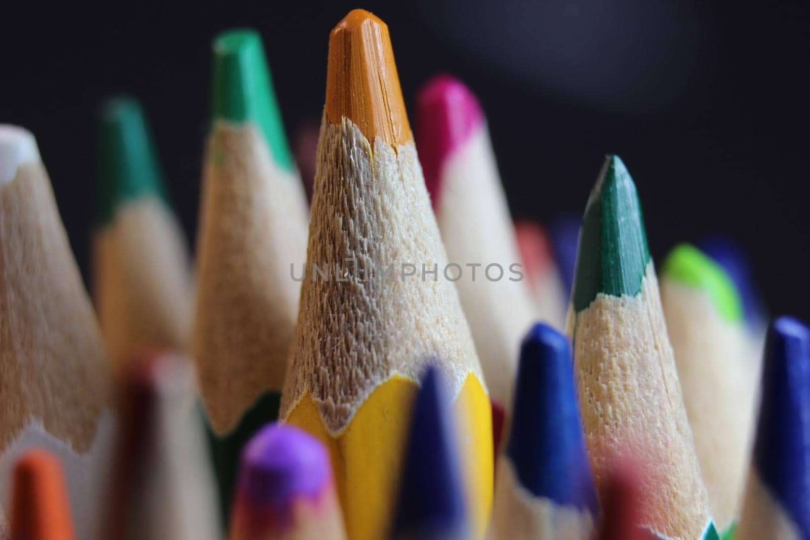 Bright colored multicolor pencils on black background by Photochowk