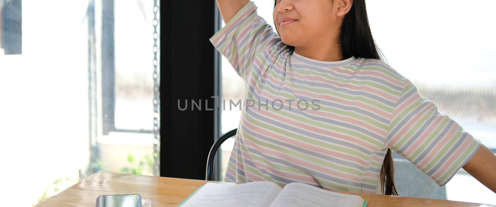 asian girl student stretching while reading book feeling tired bored sleepy. children education