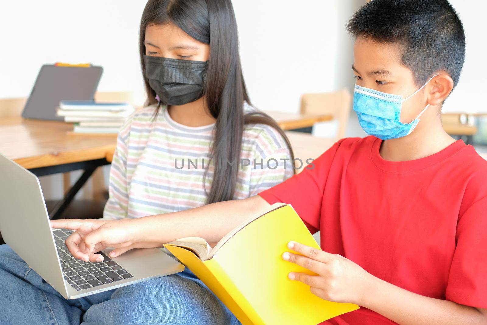 asian boy girl student wearing face mask studying learning lesson online. remote meeting distance education at home