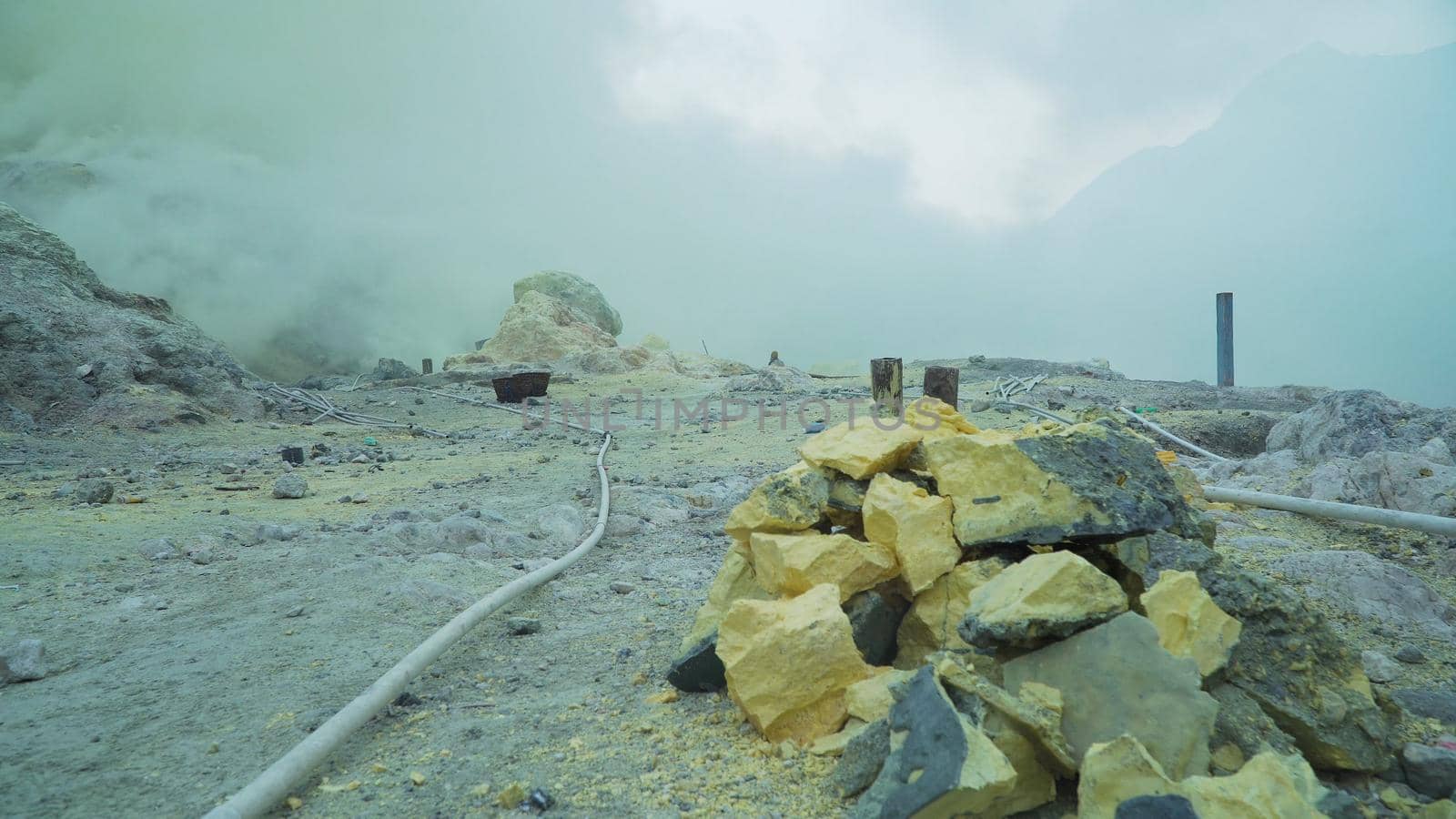 Extraction of sulfur in the crater of a volcano. Sulfur gas, smoke. Kawah Ijen, crater with acidic crater lake where sulfur is mined. Ijen volcano complex is a group of stratovolcanoes in the Banyuwangi Regency of East Java, Indonesia.