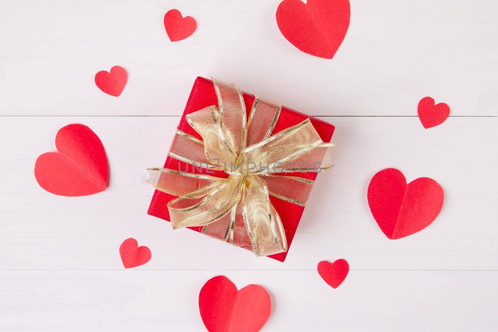 Gift box and heart shape paper on wooden table background, love and romance, presents in celebration and anniversary with surprise on desk, happy birthday, donate and charity, valentine day concept.