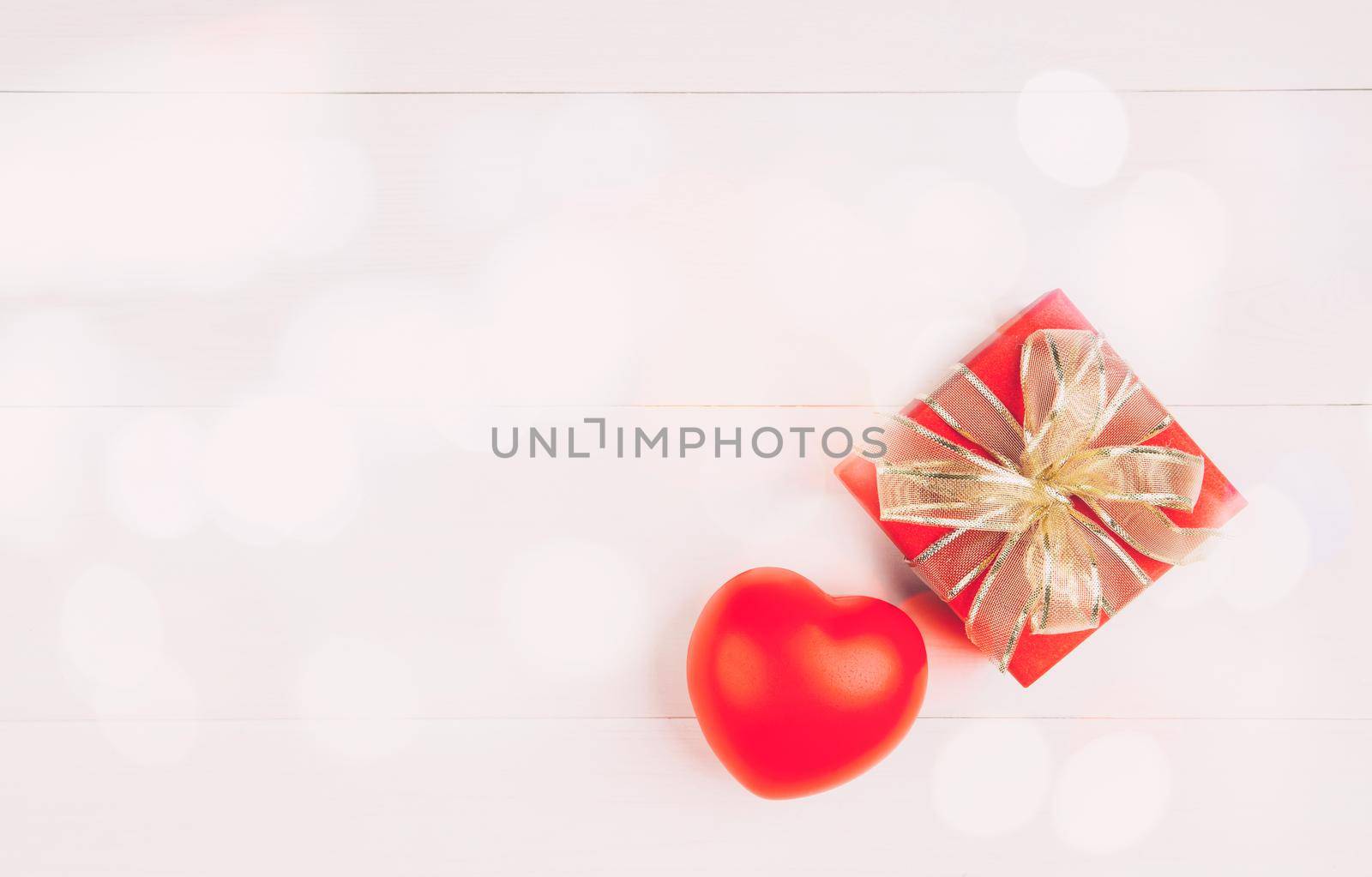 Red gift box and heart shape on wooden table background, love and romance, presents in celebration and anniversary with surprise on desk, happy birthday, donate and charity, valentine day concept.