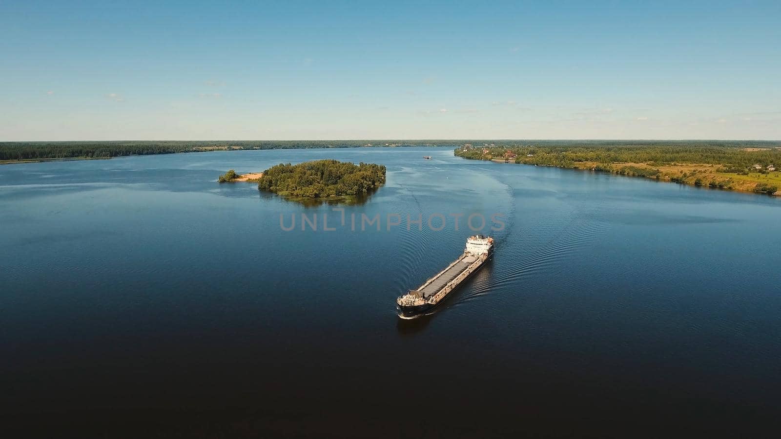 Aerial view:Barge with cargo on the river. River, cargo barge, highway with cars.. Cargo ship on the river.