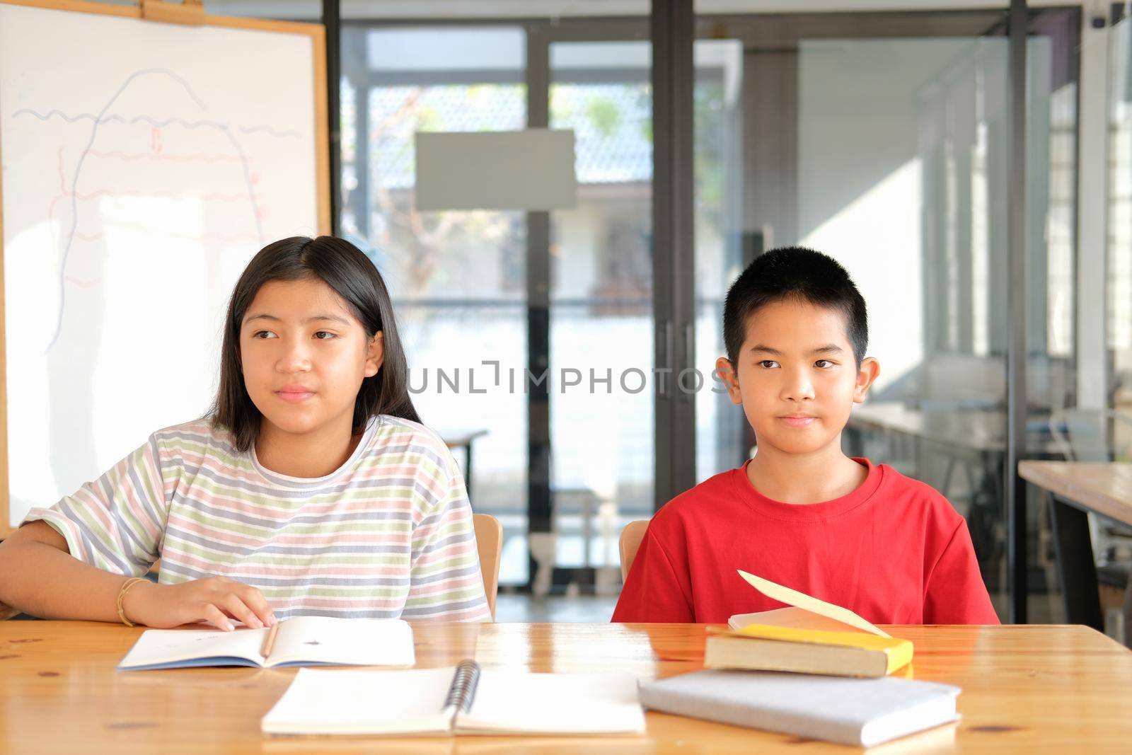 asian boy girl student studying doing homework in library. learning education at school