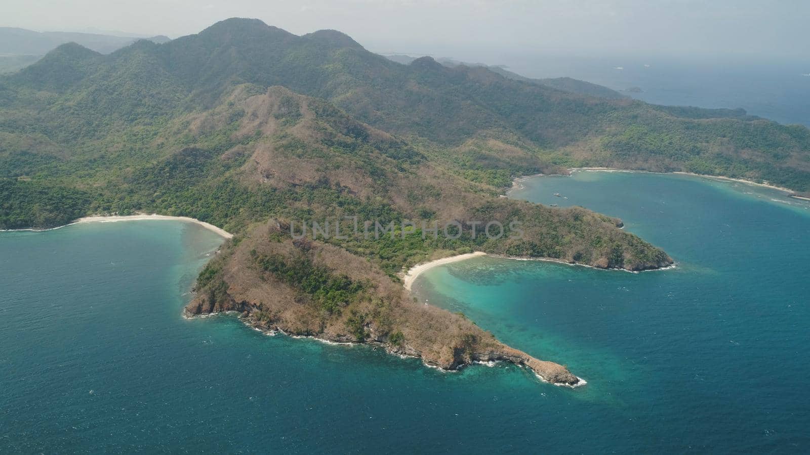 Aerial view of seashore with beach, lagoons and coral reefs. Philippines, Luzon. Coast ocean with tropical beach, turquoise water. Tropical landscape in Asia.