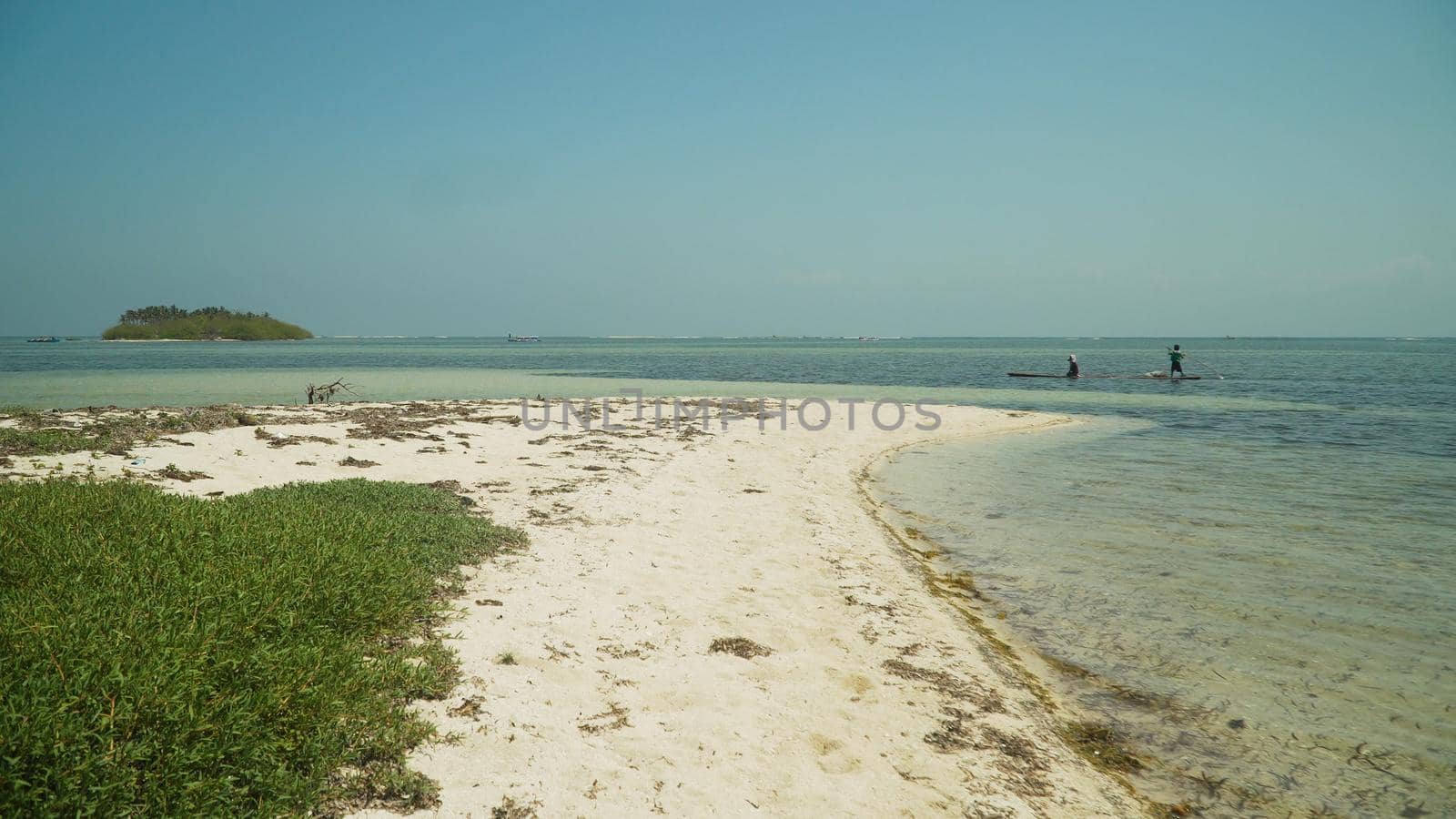 Tropical island with white sandy beach in blue lagoon. Tondol white sand beach with turquoise water. Seascape, ocean and beautiful beach. Philippines, Anda, Pangasinan. Travel concept.
