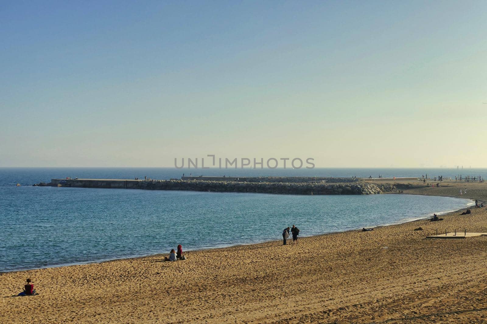 Panoramic view of sand beach inlet and pier with few people by lemar