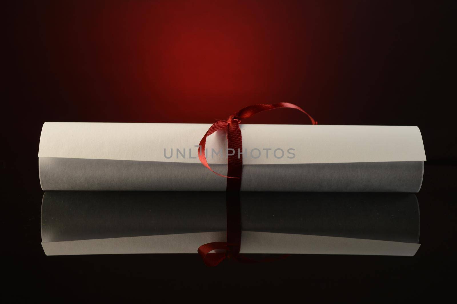 A successful graduation diploma tied in a red ribbon over an atmospheric background.