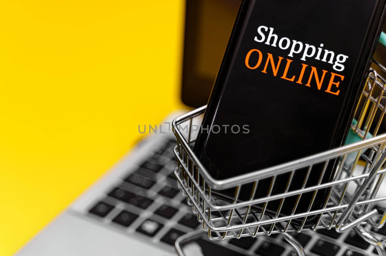 Shopping cart with smartphone on notebook. Online shopping concept. by dmitrimaruta